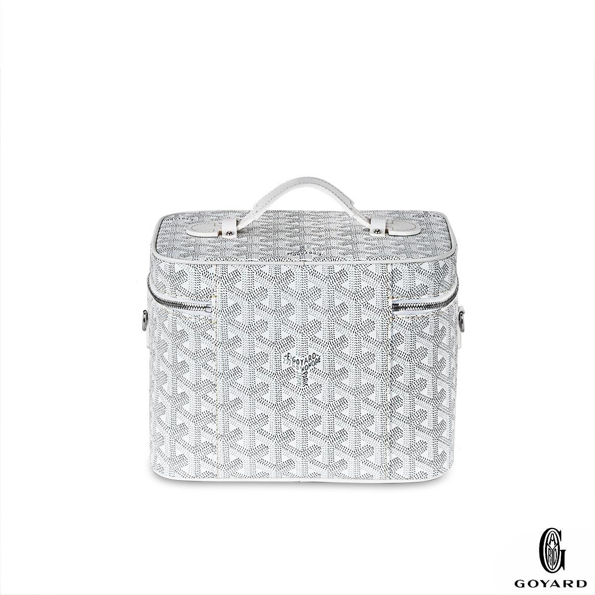 An amazing white Muse Vanity Case by Goyard. The exterior is crafted in white Goyardine Canvas and Cervon Calfskin complemented with palladium hardware and a double zipper. The interior features a yellow water repellant cotton lining, a removable