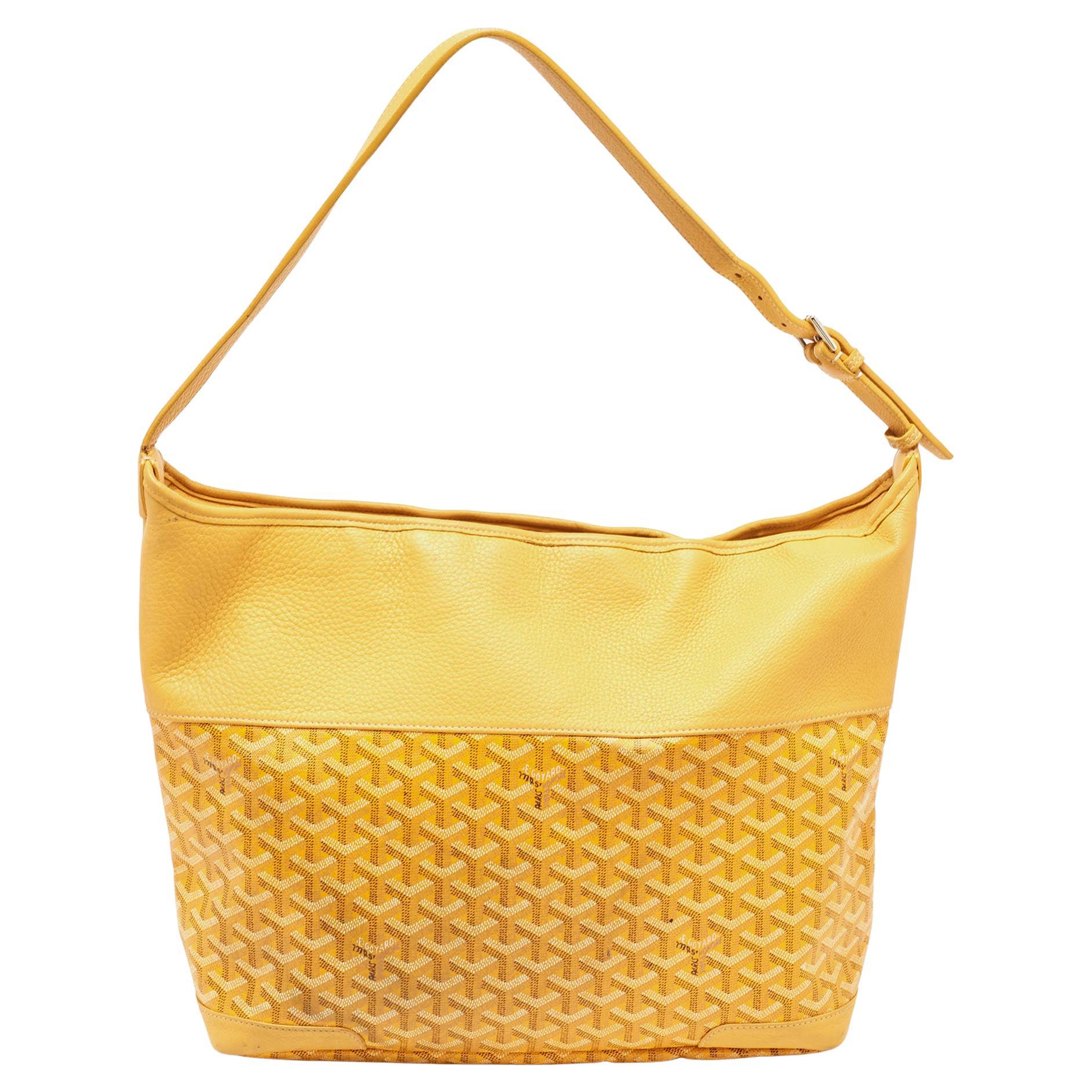 Ce sac à main de Goyard réalisera le rêve d'innombrables femmes. Confectionné en toile enduite et en cuir, ce sac est d'un jaune éclatant. Tandis que la forme et les détails rehaussent sa beauté, l'intérieur en tissu accueillera consciencieusement