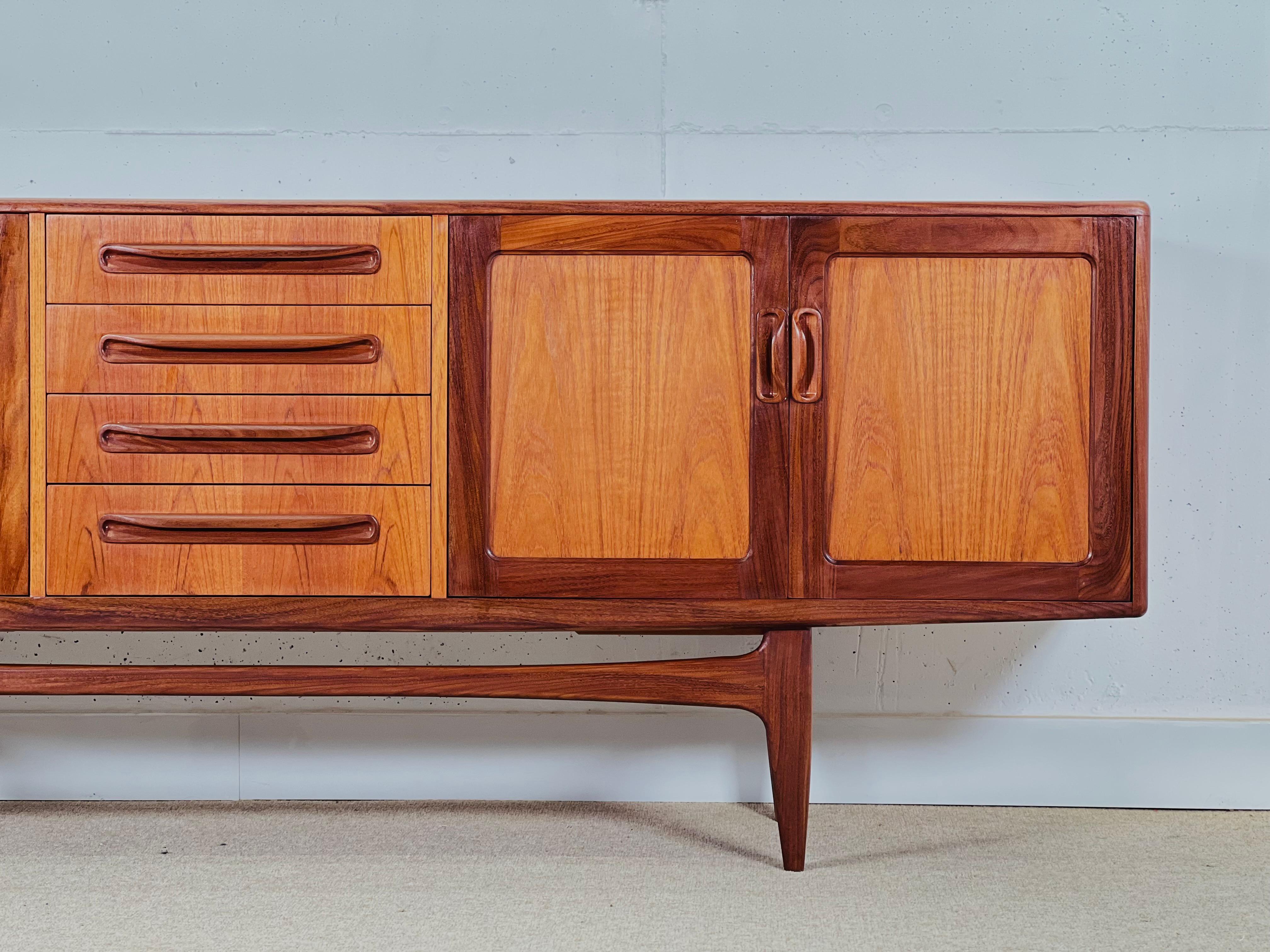 Buffet du milieu du siècle de GPlan, conçu par Victor Wilkins pour sa Collection Fresco dans les années 1960.

Le buffet est composé d'un module à 4 tiroirs au centre, à droite d'un meuble bar et à droite d'un meuble à deux portes. Fabriqué en teck