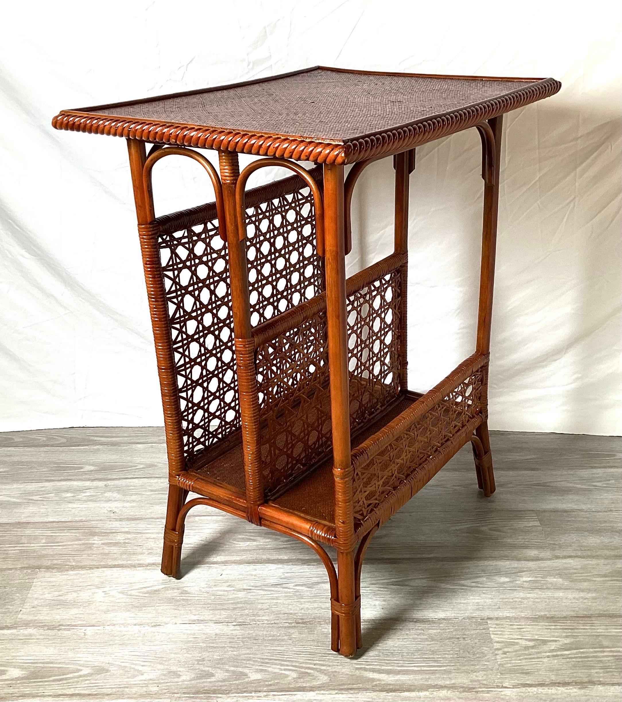Une table d'appoint en bambou du début du 20e siècle pour le rangement et la lecture. Le plateau rectangulaire avec compartiments latéraux, les côtés cannelés reposant sur quatre pieds en bambou. Le dessus est en bois recouvert de bandes de bambou