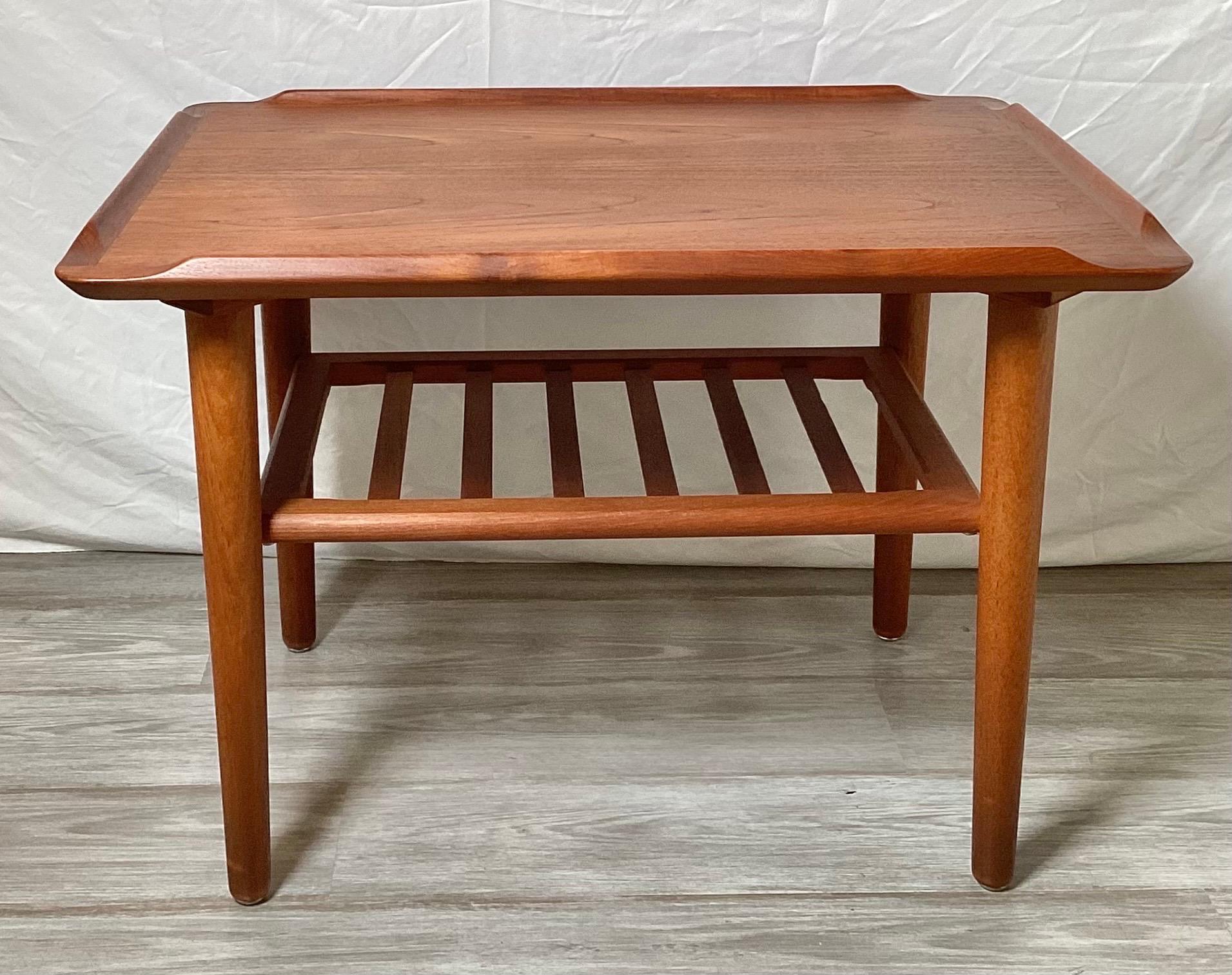 An original Poul Jensen vintage modern teak accent table with a sculptural top and slatted shelf.   The piece is in great condition and ready to be placed in your home.  It is labeled and numbered underneath.  