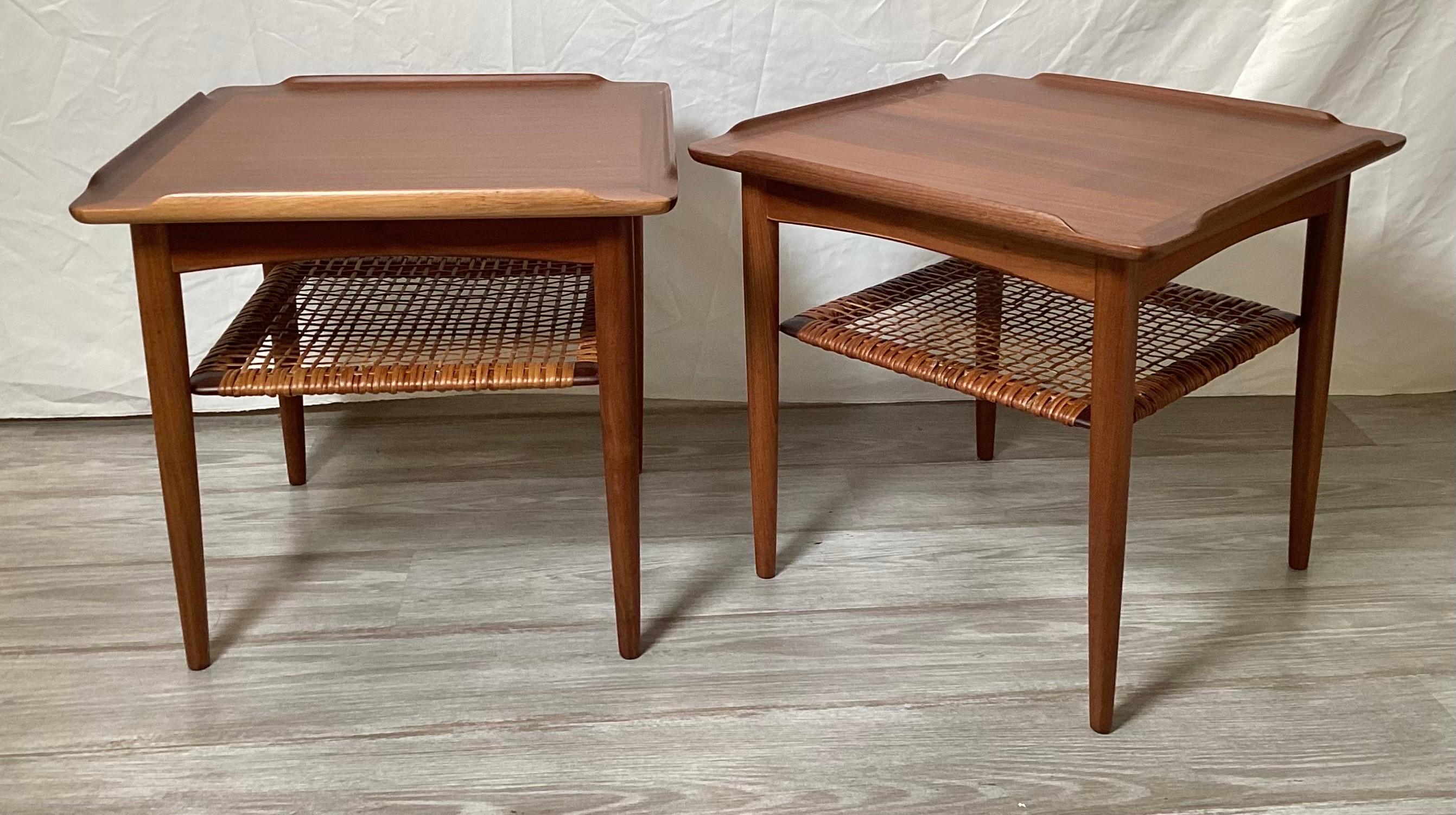 A Pair of Teak end tables with woven cane lower shelves by Poul Jensen for Selig.  Both tables have been professionally cleaned up and touched up.  Both are in excellent condition.