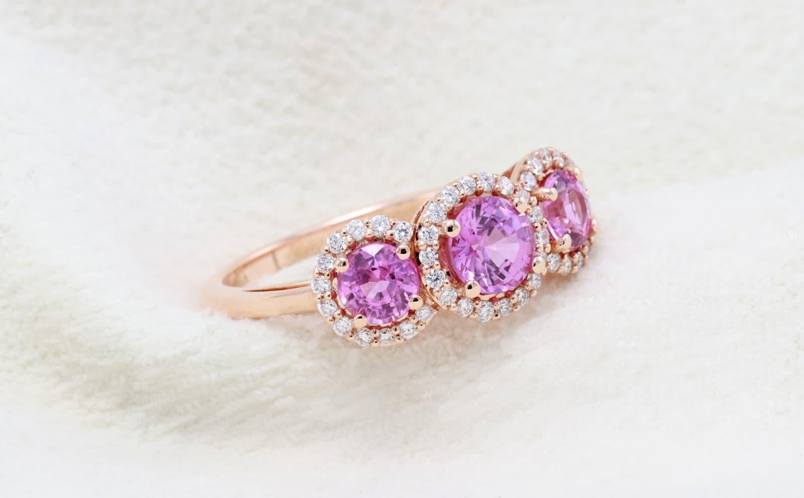 18kt white gold ring with diamonds
  
  Gold colour & karat: White gold 18kt
  Weight: 3.11 grams
  
  Set with-
  Stone type: Sapphire
  Shape: Round
  Carat: 1.30 ct
  Colour: Pink
  
 
  Surrounding Stones: Diamonds

 1) Side White Diamonds
 