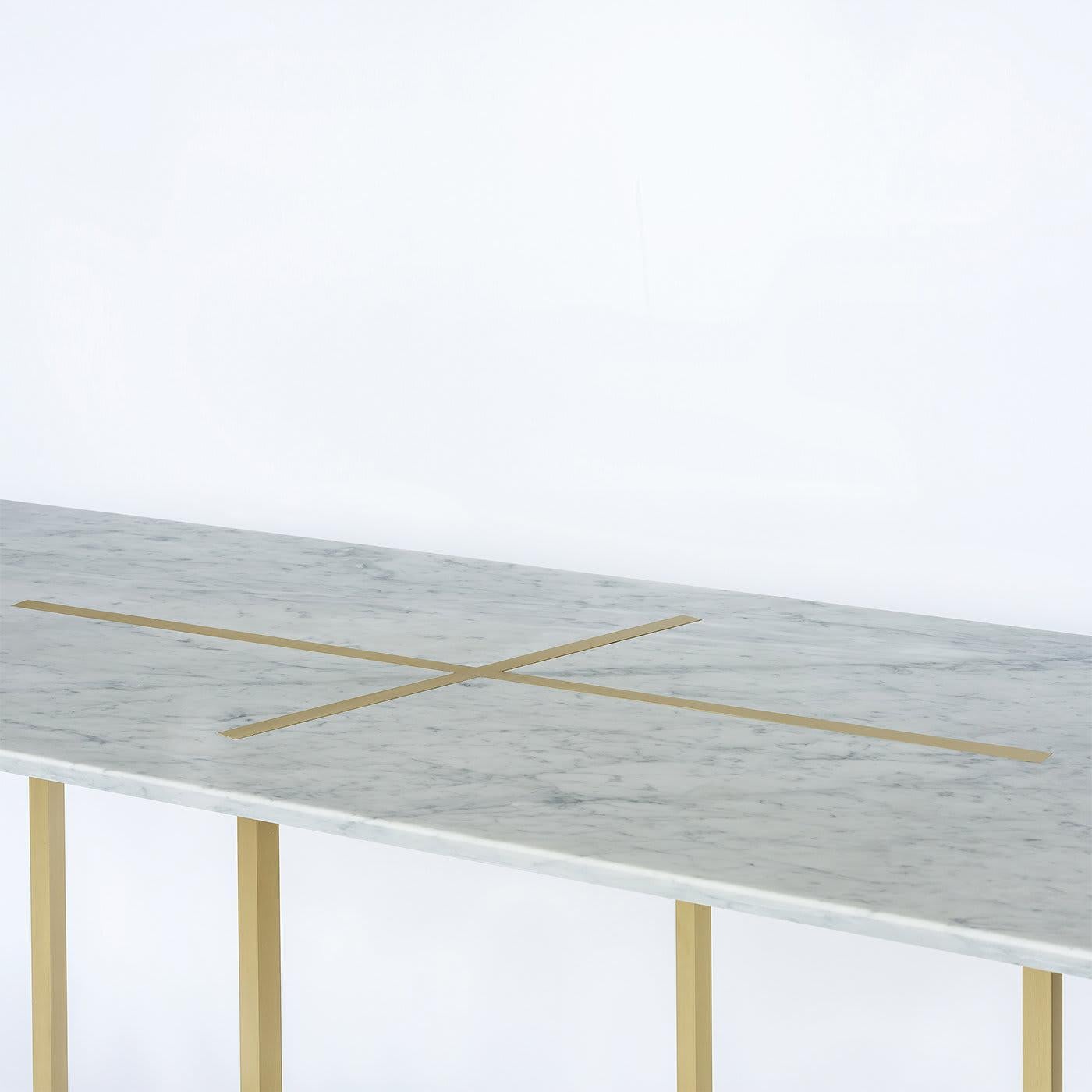 Expanding on the “Eclipse” table series, this dining table features a thick slab of white Carrera marble. 
The slim figured frame is made of solid brushed brass.