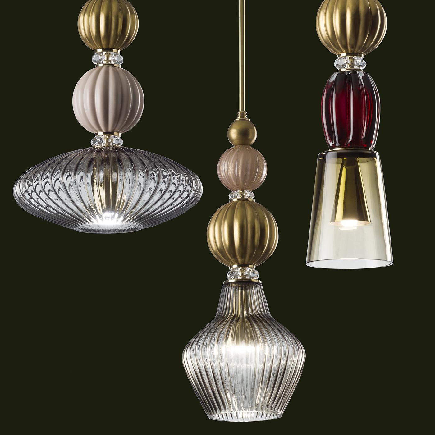 A masterpiece of elegance and artistic craftsmanship, this pendant lamp is a stunning piece of functional decor. Its vertical stem in brass (adjustable and max 200 cm high) is adorned with a stack of porcelain spheres embellished with delicate