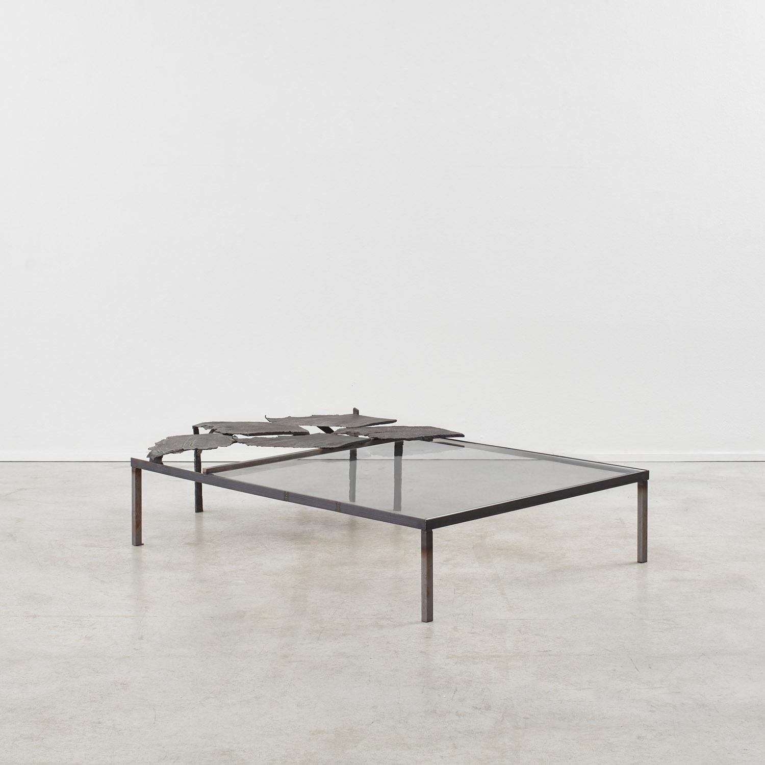 Bronze coulé, verre à faible teneur en fer et fer.

L'organicisme du fragment de bois moulé juxtapose le cadre rationaliste du fer. Un processus de patinage créatif comprend l'application de poussière de bronze provenant du sol de la fonderie.