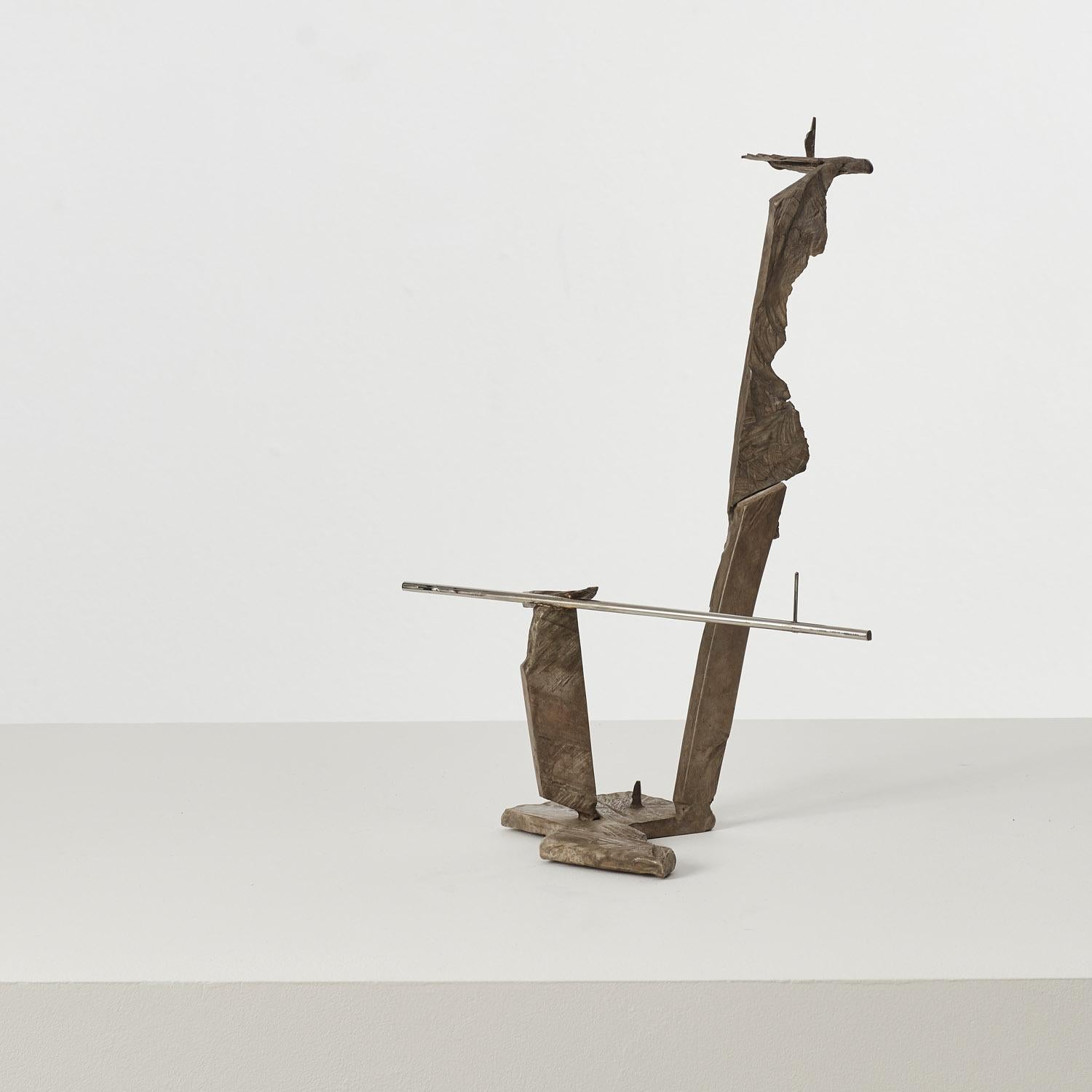 Cast bronze and polished stainless steel. 

Polished steel rods intersect with cast bronze elements, introducing the cast wood fragment to this kinetic candle holder. Deceptively robust, this piece plays with notions of structure, balance and form.