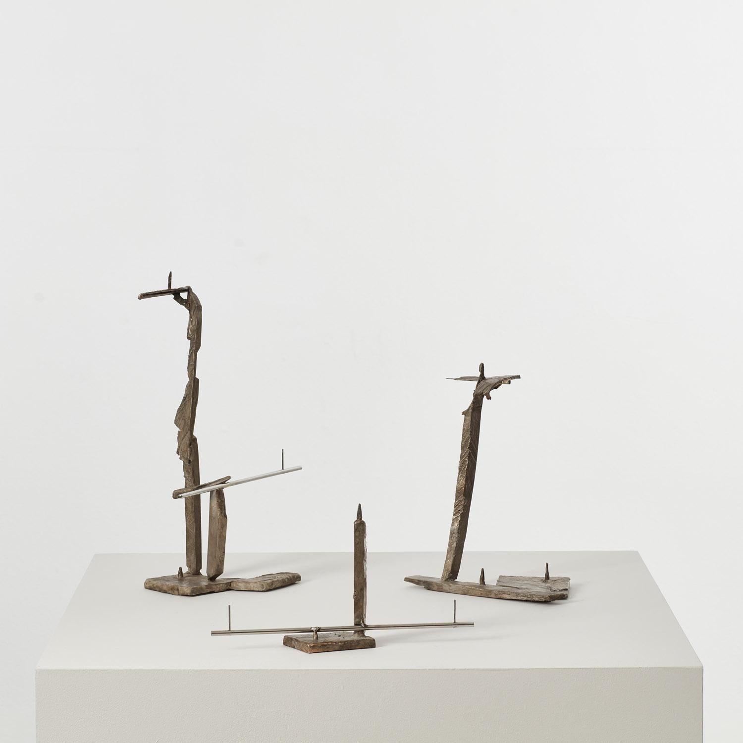 Cast bronze and polished stainless steel. 

Polished steel rods intersect with cast bronze elements, introducing the cast wood fragment to these kinetic candle holders. Deceptively robust, the pieces play with notions of structure, balance and form.