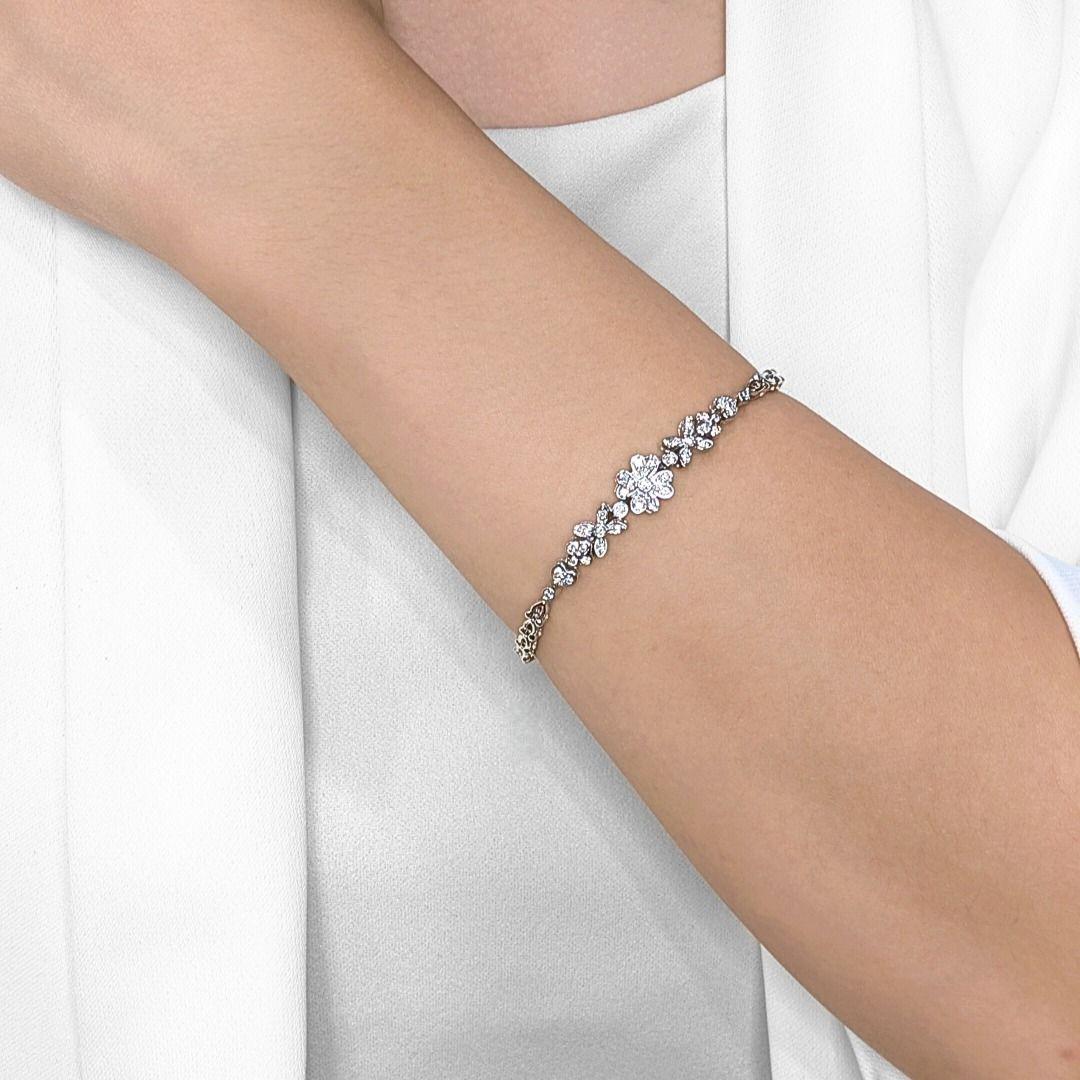 Gracefully feminine with a timeless sparkle, this floral-inspired bracelet features 41 round brilliant natural diamonds totaling 0.41 carats, set in luminous 18K white gold. The intricate flower motifs bring a romantic charm, enhanced by G-H color