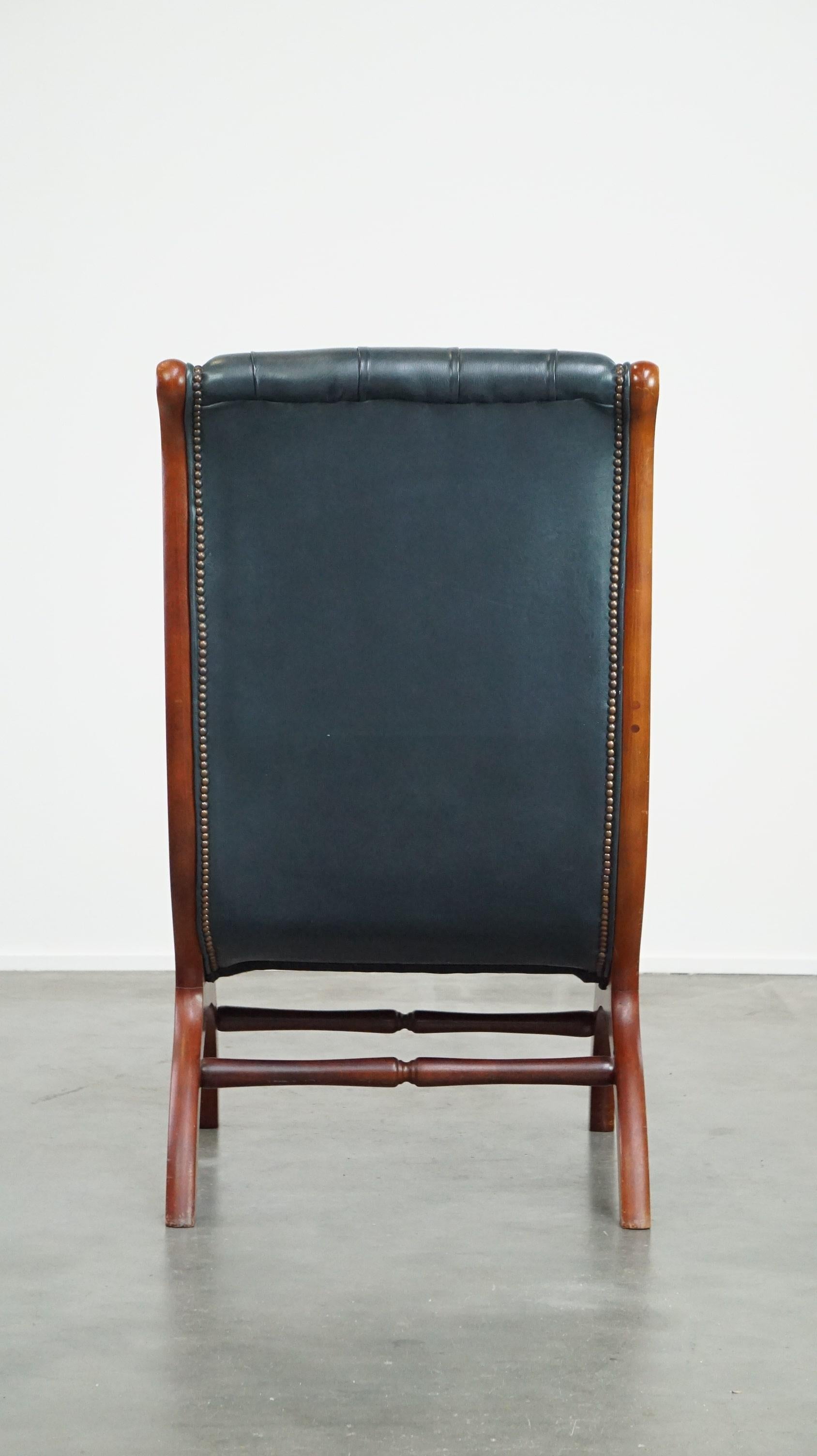 Hand-Crafted Graceful dark blue chesterfield armchair made of cow leather combined with wood For Sale
