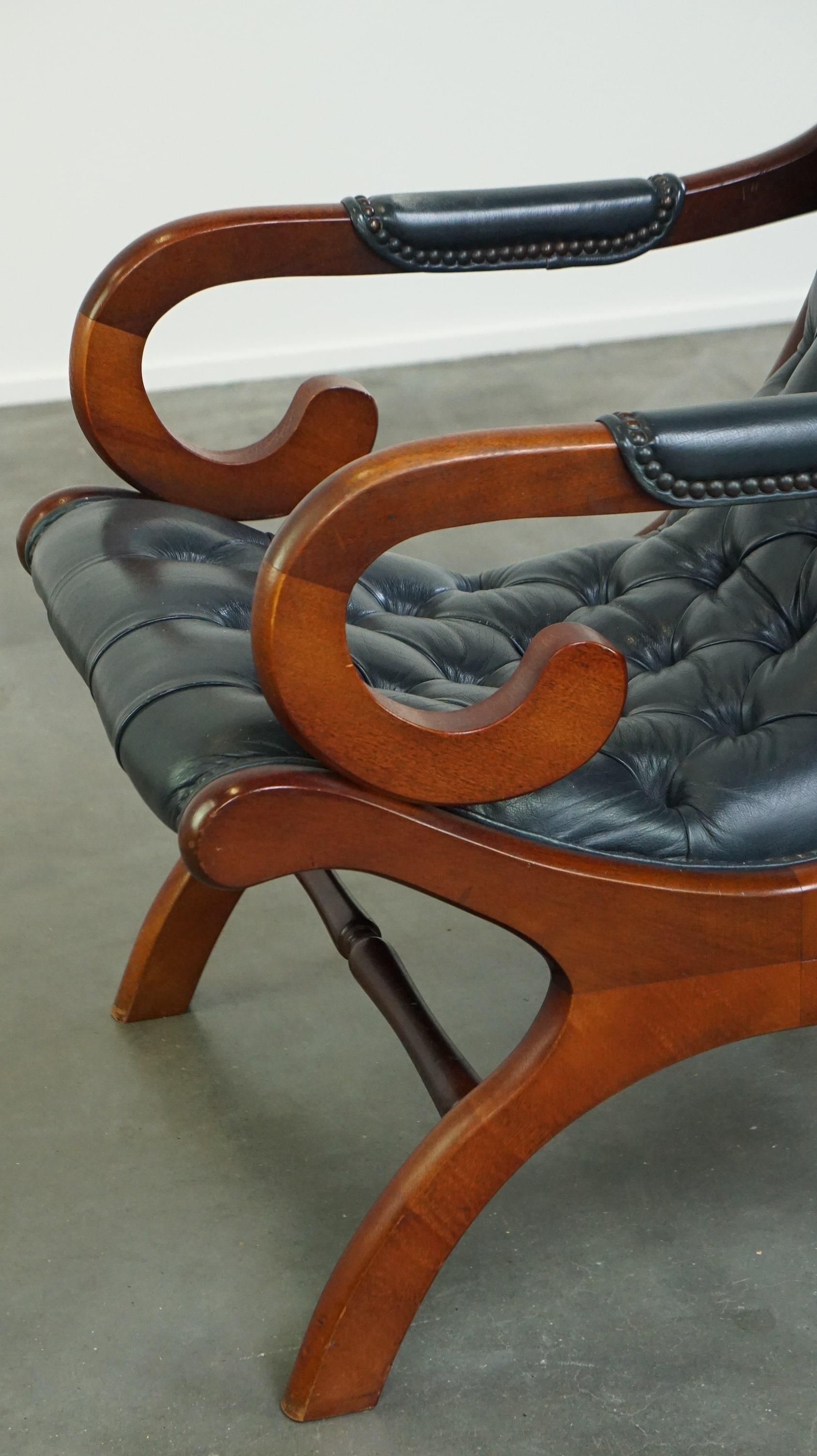 Graceful dark blue chesterfield armchair made of cow leather combined with wood For Sale 2