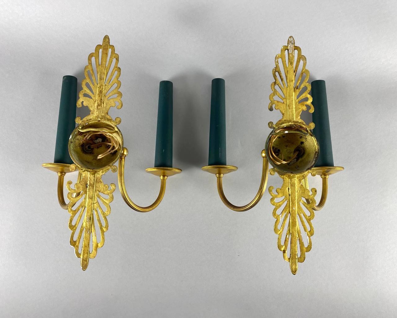 Vintage brass paired wall lamps in Empire Style.

 It features bright gold and green enamel finishes.

 The light is connected to the support using a short arm.

 And at the end of each arm there is a bobesh carrying a lamp holder. 

 The