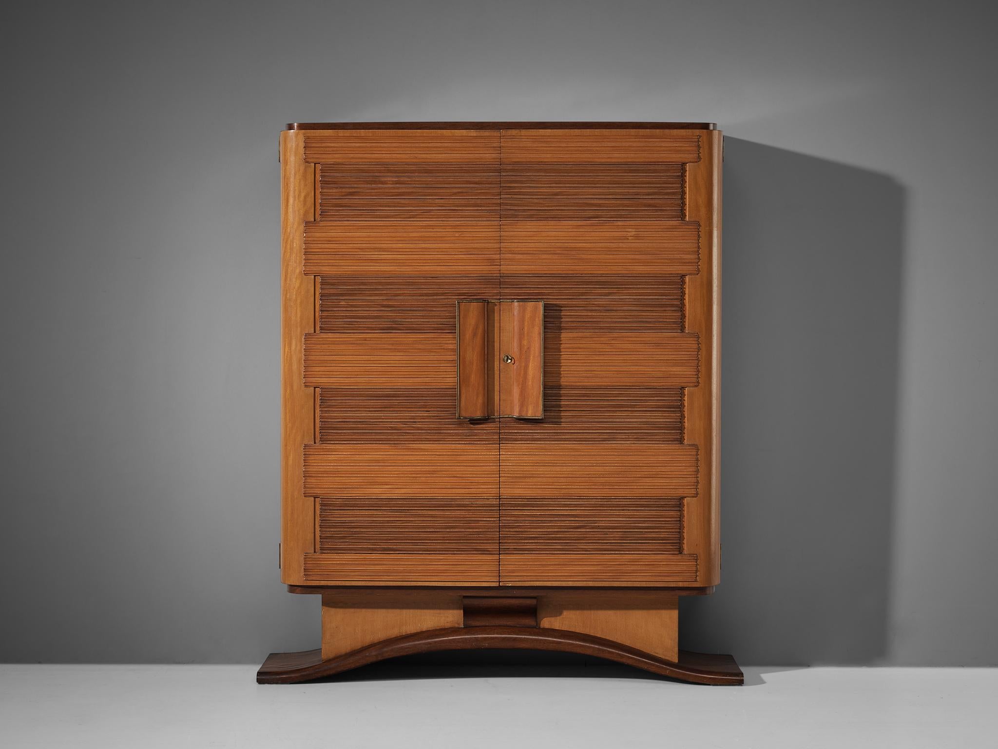Armoire, brass, mirrored glass, glass, mahogany, cherry, Italy, 1950s 

This charming armoire convinces visually through its graphical door panels composed of carved horizontal lines that specialize the design and highlight the admirable