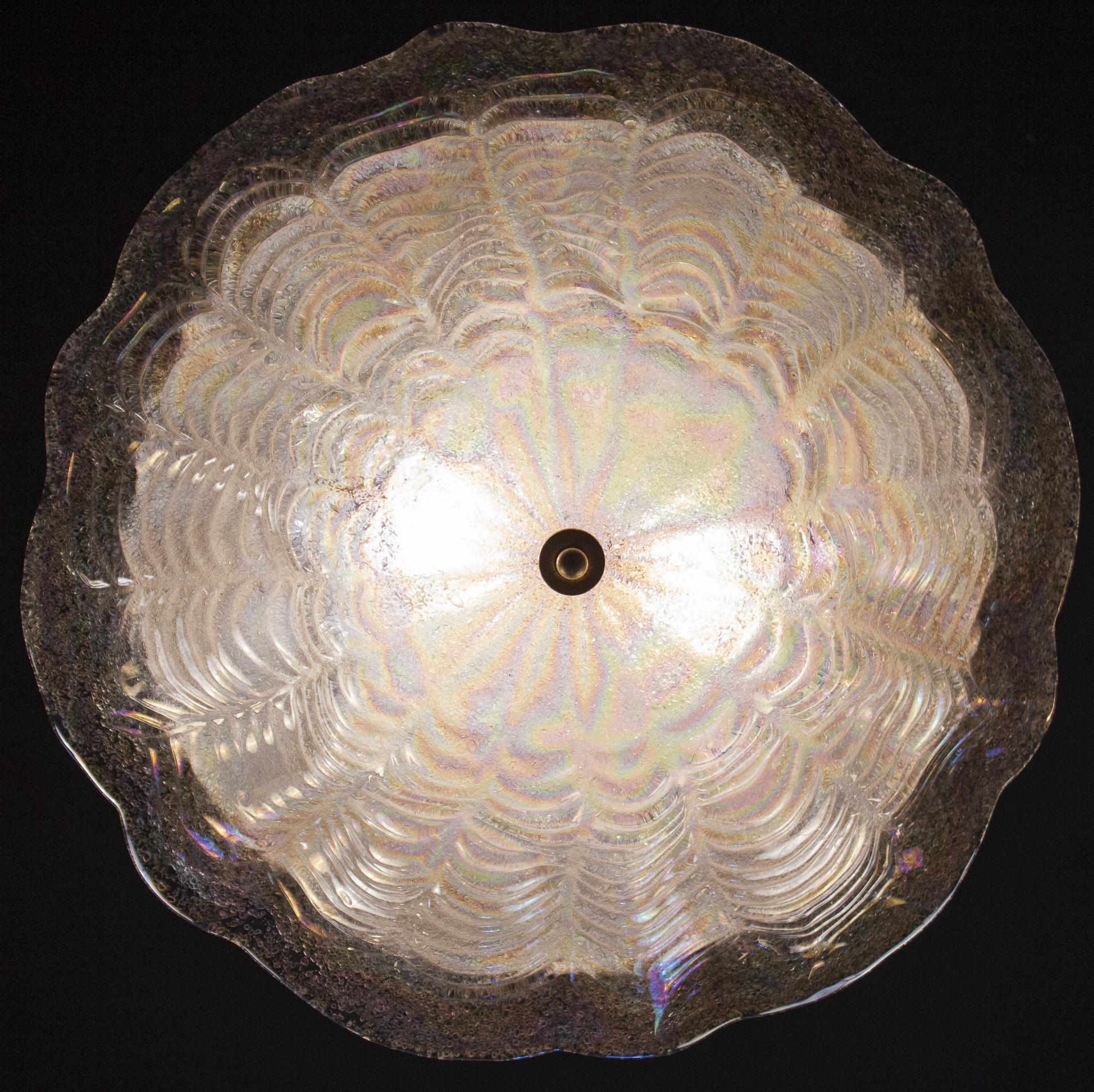 This amazing ceiling light realized in a pure Iridescent Murano glass, giving a special light effect even when switched off.
Two E 27 lights spread a magical light.

Measures: Diameter 55 cm, height 20 cm.