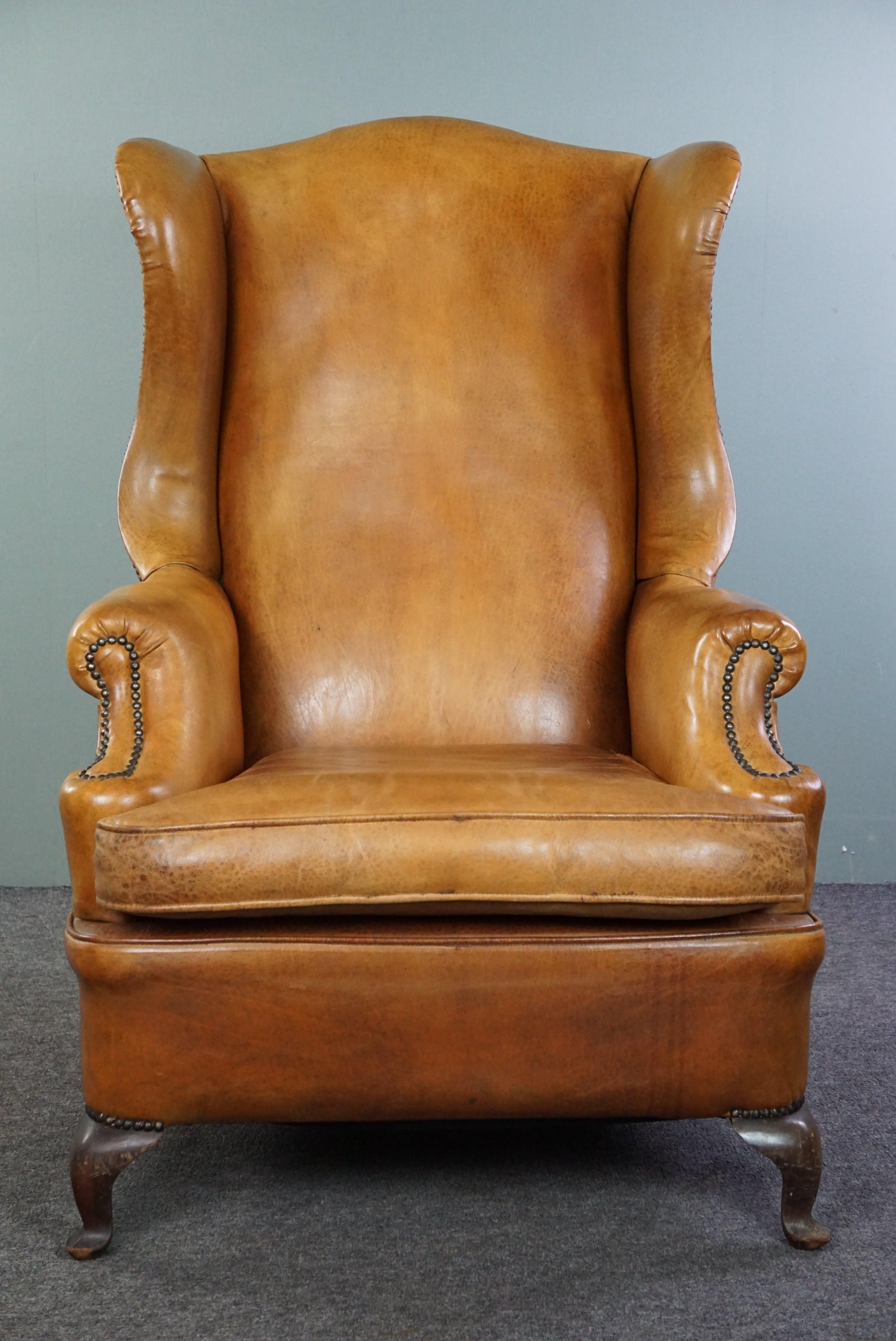 Dutch Graceful old wing chair made of sheep leather in correct condition For Sale