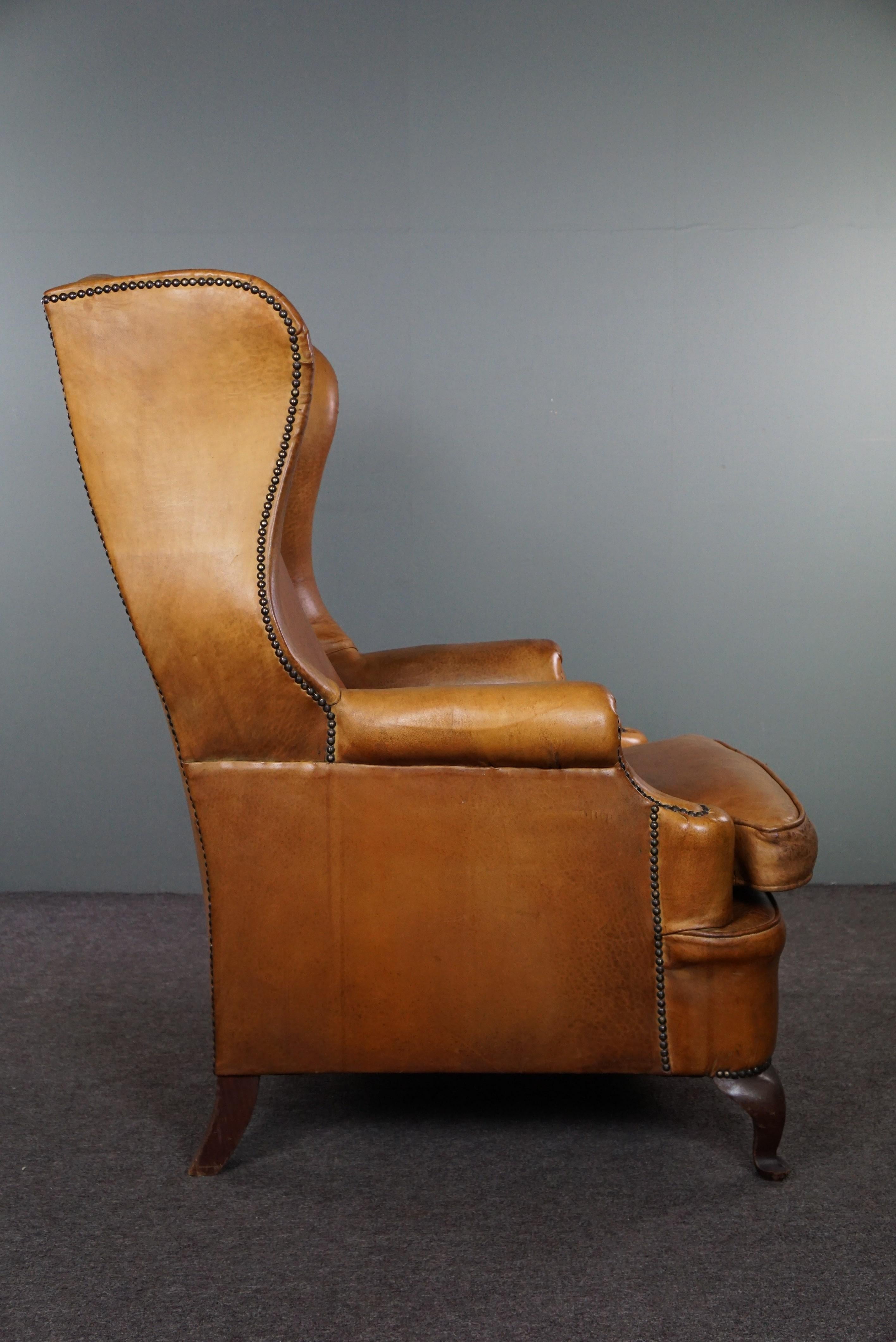 Hand-Crafted Graceful old wing chair made of sheep leather in correct condition For Sale