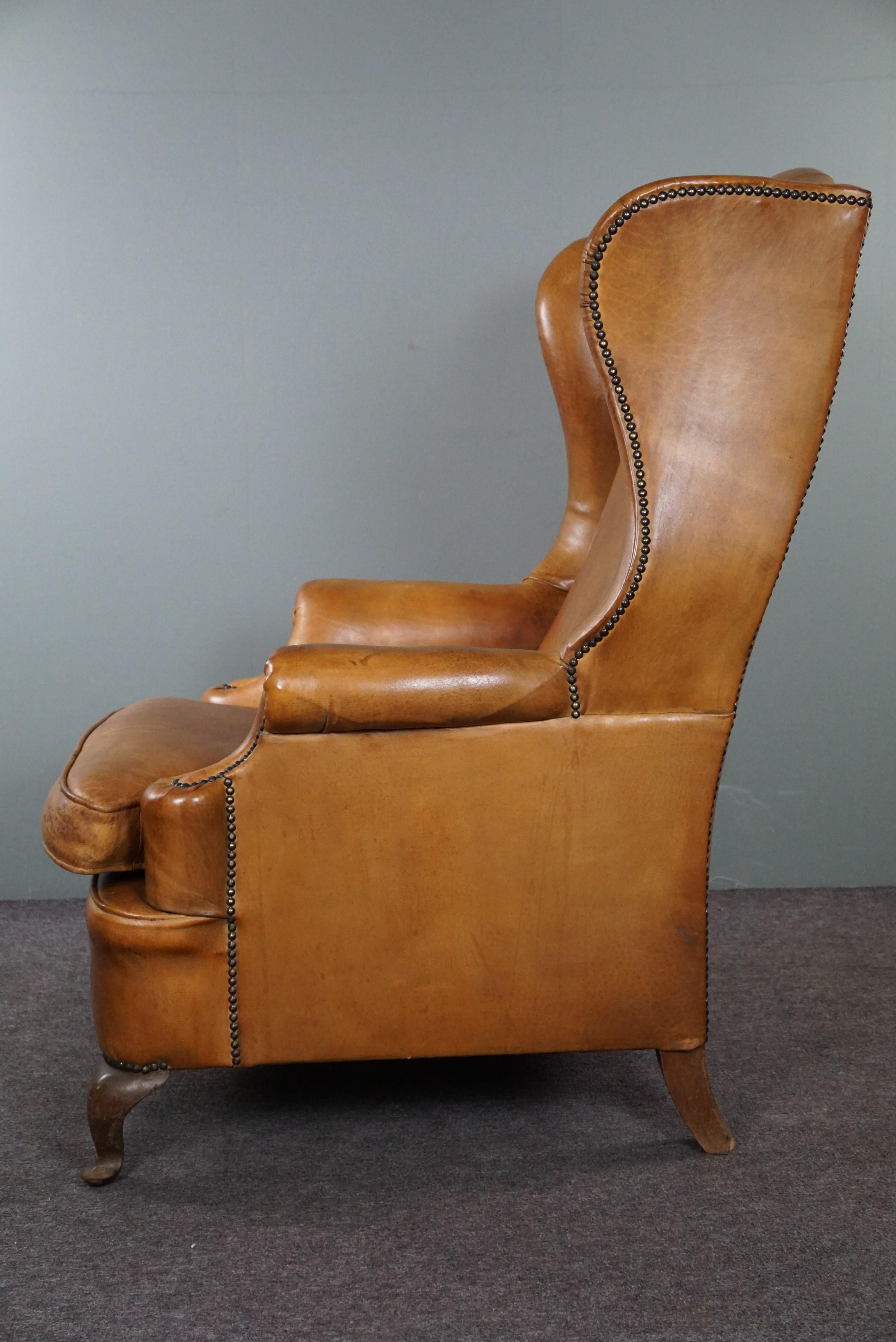 Contemporary Graceful old wing chair made of sheep leather in correct condition For Sale