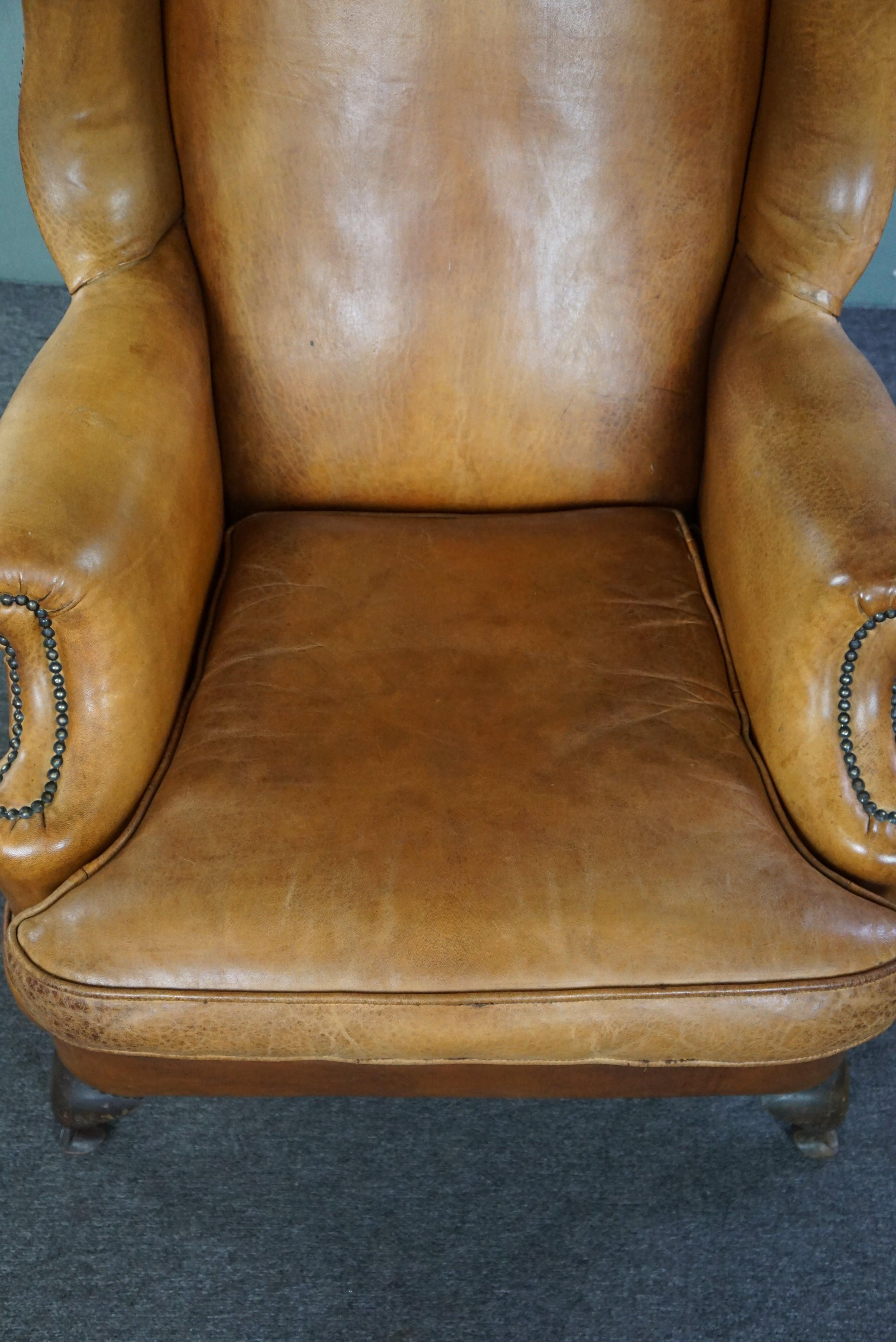 Leather Graceful old wing chair made of sheep leather in correct condition For Sale