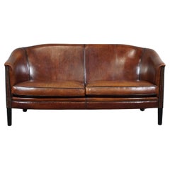 Gracefully shaped sheep leather sofa finished with black piping, spacious 2 seat