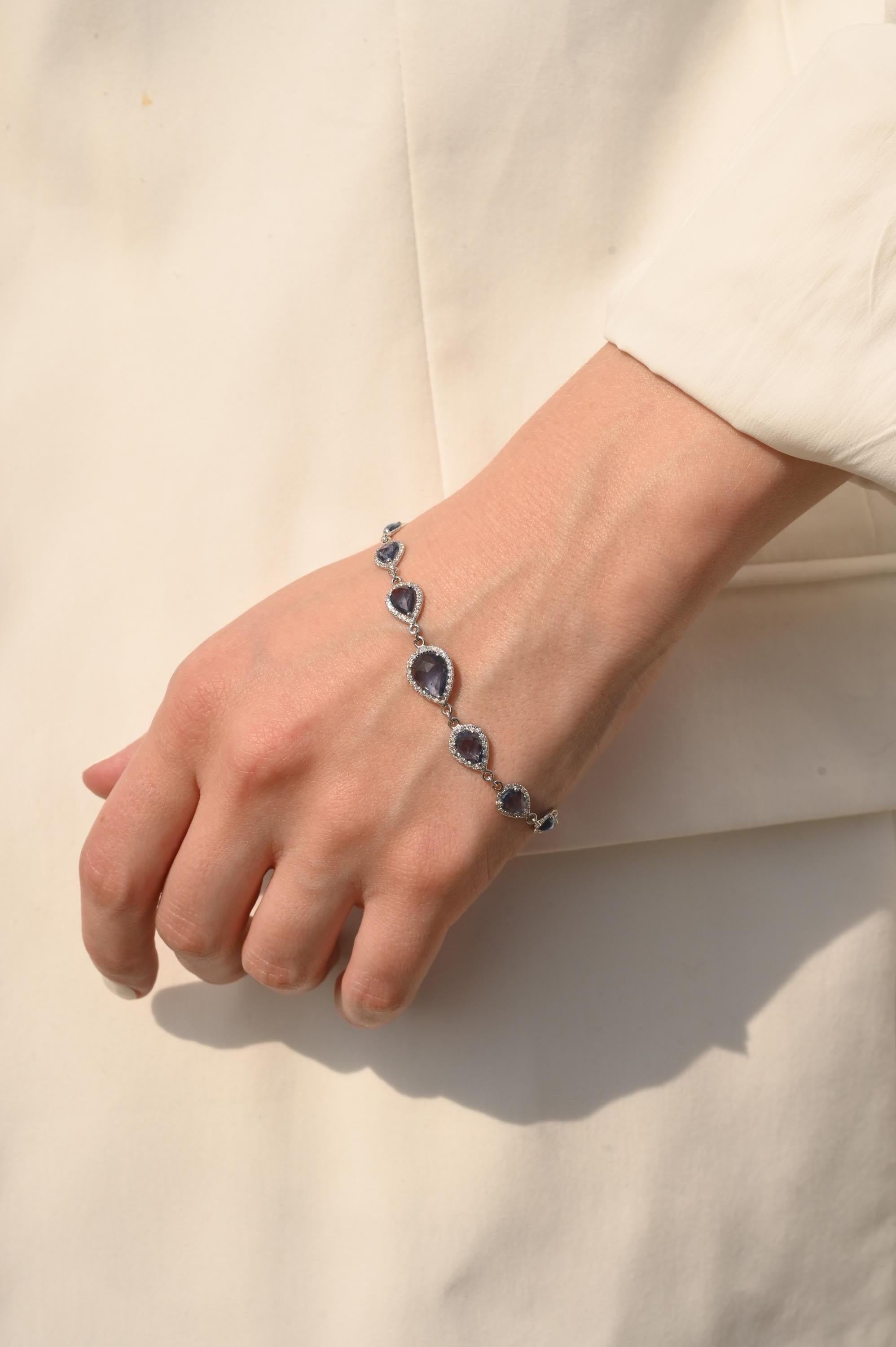 Il bracciale Gradient Pear Cut Sapphire and Halo Diamond in oro 14K mette in mostra 9 zaffiri blu naturali infinitamente scintillanti del peso di 5,7 carati e diamanti del peso di 0,51 carati. Misura 7.25 pollici di lunghezza. 
Lo zaffiro stimola la