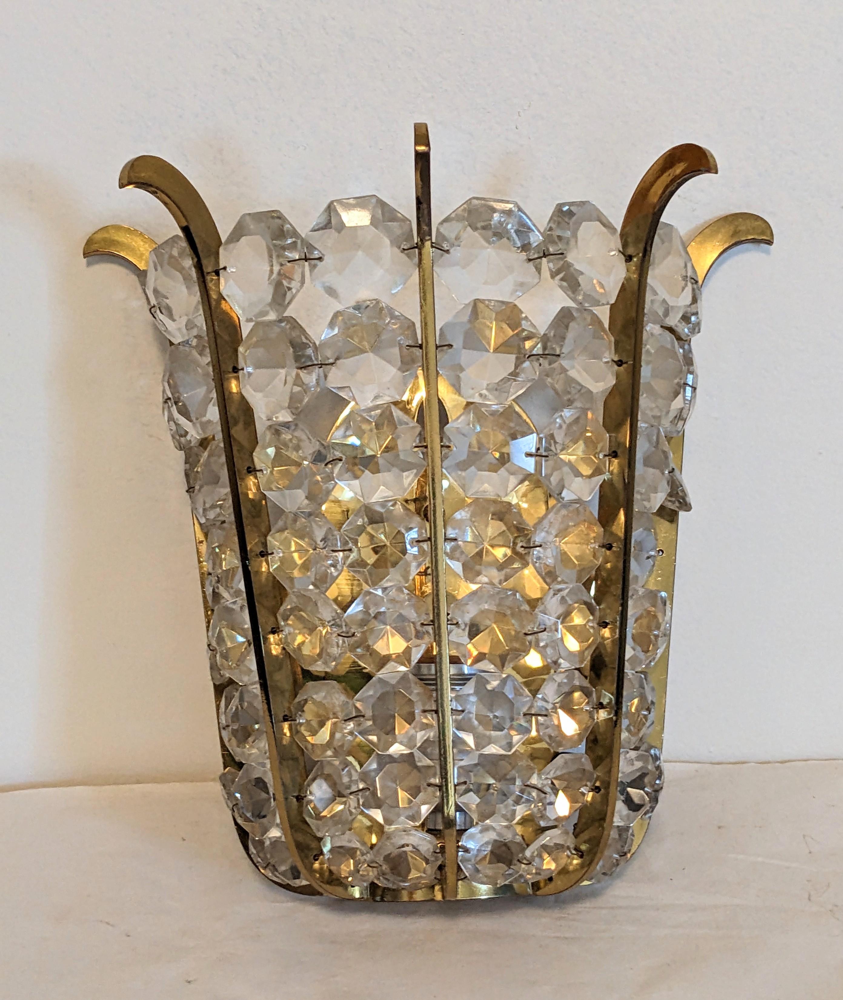 Elegant Graduated crystal sconce attributed to Kinkeldey, Germany from the 1960s. Shaped gilt arms are set with graduated crystals which taper down into a tulip form shape. Unsigned. 1960s USA.