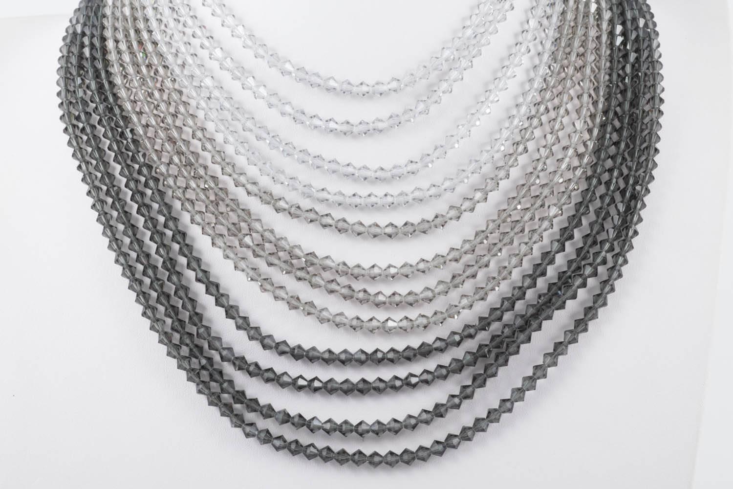 Un beau collier en cristal à plusieurs brins, fabriqué en Autriche dans les années 1960, douze rangées dans des teintes graduées de gris, du gris clair doux au gris foncé fumé, avec un terminal de pâte à main à chaque extrémité. Une pièce de l'âge
