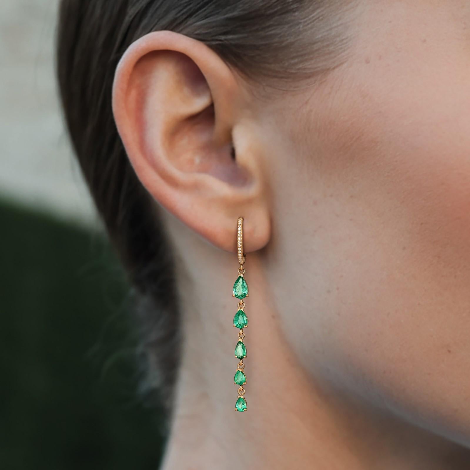 These graceful dangler earrings are crafted in 14K Yellow Gold, featuring a stunning combination of diamonds, emeralds, and pink sapphires. With a total weight of 3.04 grams, the earrings showcase vibrant emeralds (2.11CT) that elegantly complement