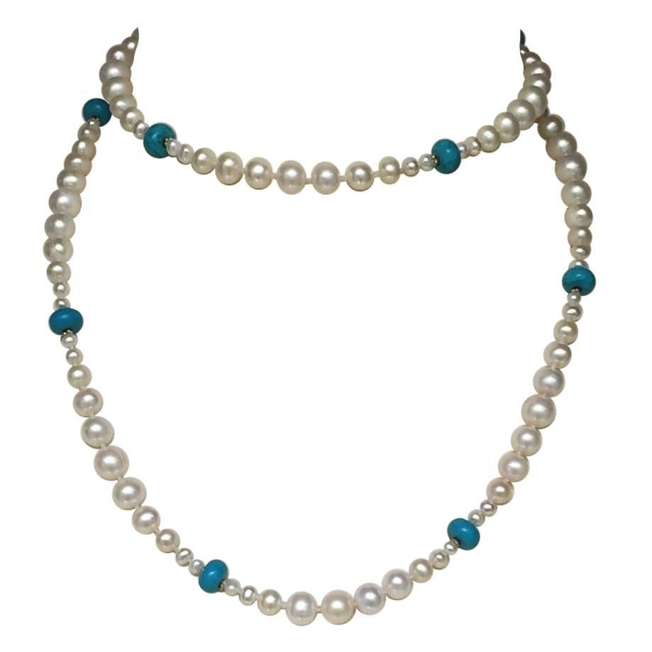 This beautiful necklace has graduated pearls with brilliant blue turquoise and 14 k yellow gold beads with a tassel. The pearls glow in contrast to the turquoise and small gold beads with a 14 k gold clasp. The removable tassel also has graduated