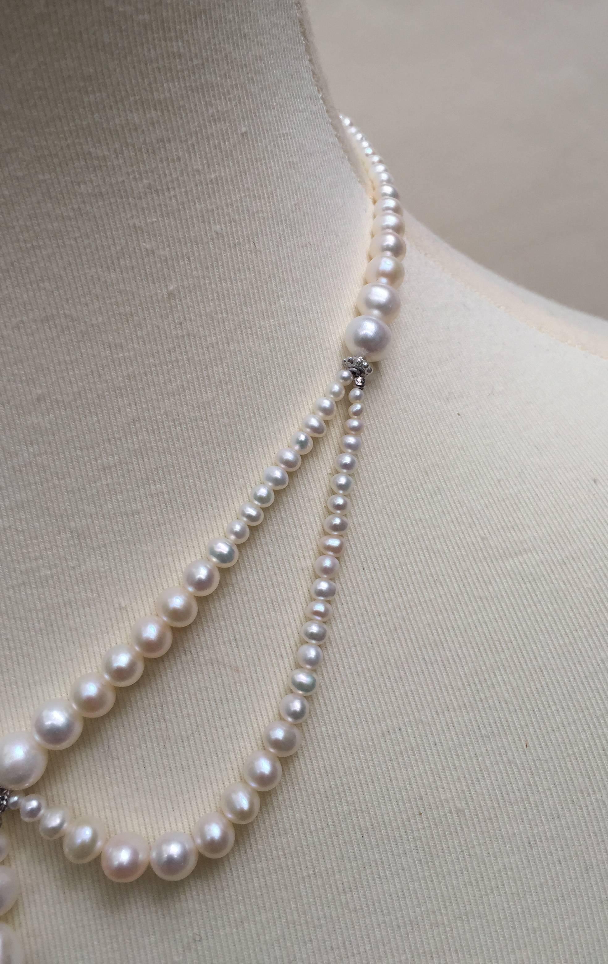 This beautiful pearl necklace is shaped with graduating pearls around the neckline and two graduated pearl drapes highlighting the collar bones. The center of the necklace has three graduated pearls hanging from a beautiful 14k white gold bead. At