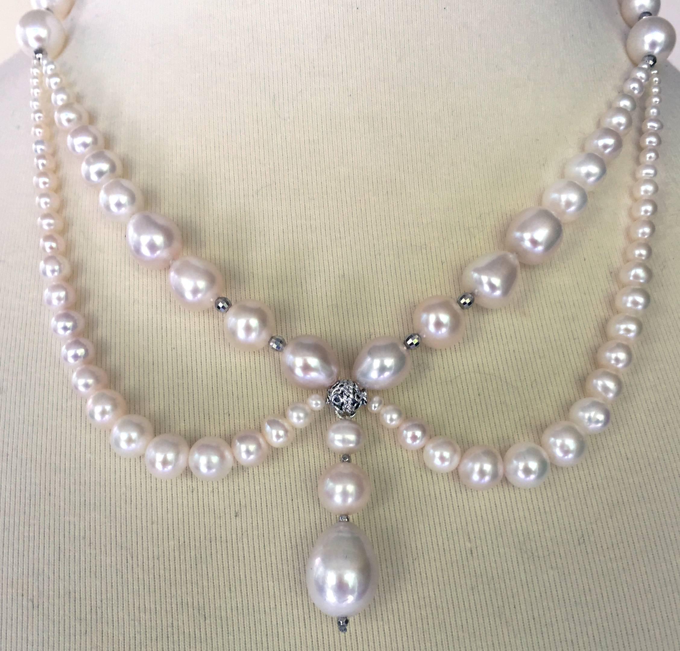 This beautiful pearl necklace is shaped with graduating pearls around the neckline and two graduated pearl drapes highlighting the collar bones. The center of the necklace has three graduated pearls hanging from a beautiful silver rhodium plated