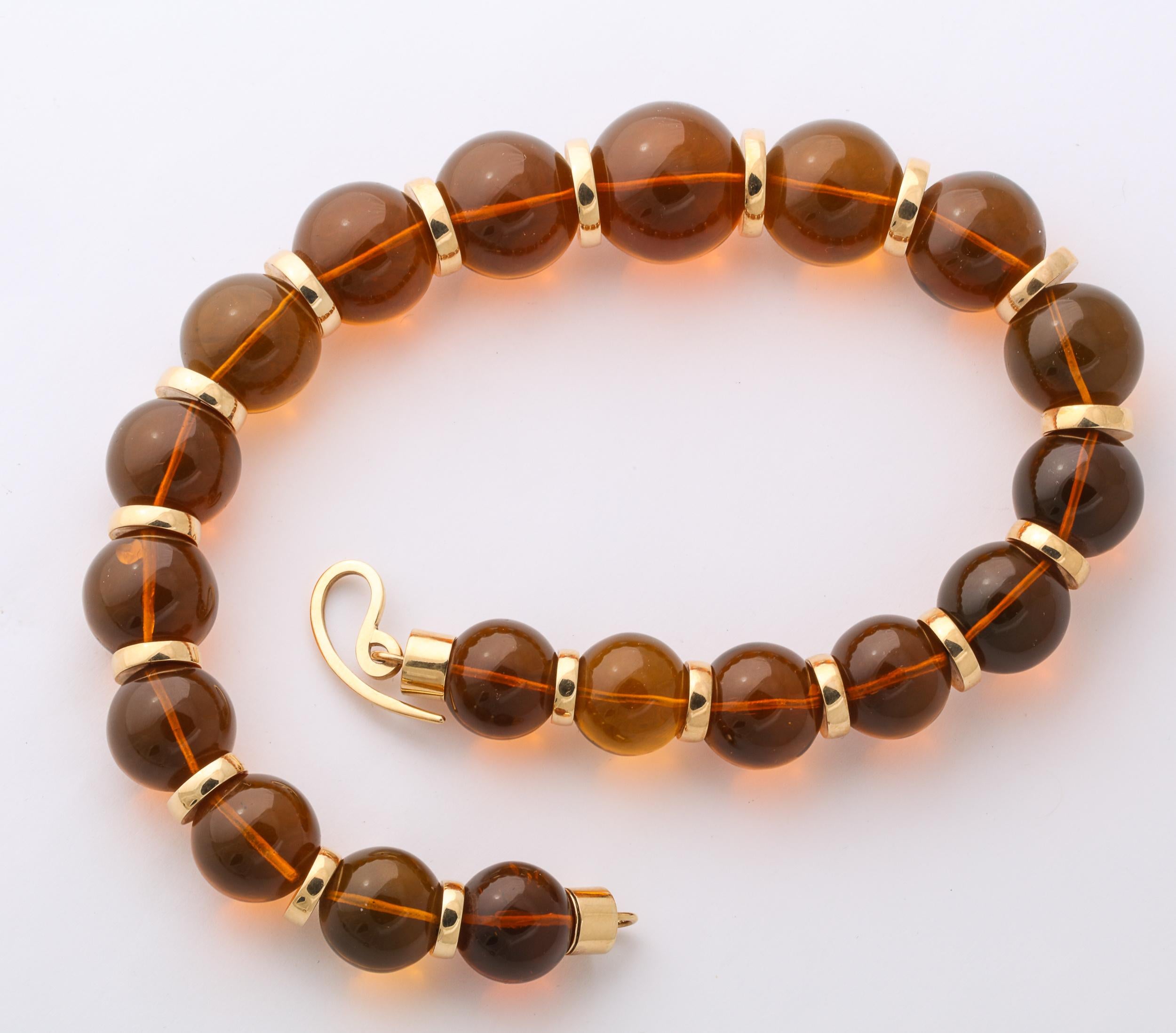 Magnificent reconstituted  polished  Amber Beads ranging from 18 to 25 mm - and separated by 18t Yellow Gold Rondels measuring from  11 to 16 mm x 3 mm
The Beads are terminated by cylindrical ends  and a free-form 18kt Yellow Gold Clasp.
Very bold