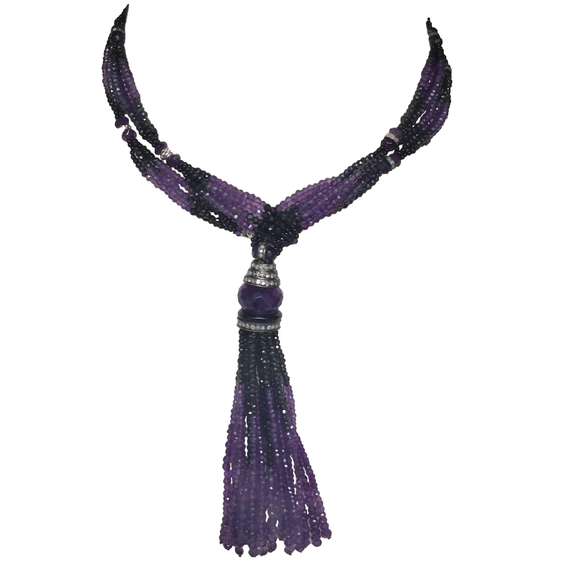 This graduated spinel and amethyst lariat necklace with diamonds and 14k white gold is a dramatic statement piece. The necklace has beautiful black spinel that flow into the amethyst beads in graduated sections. Slightly larger amethyst beads a