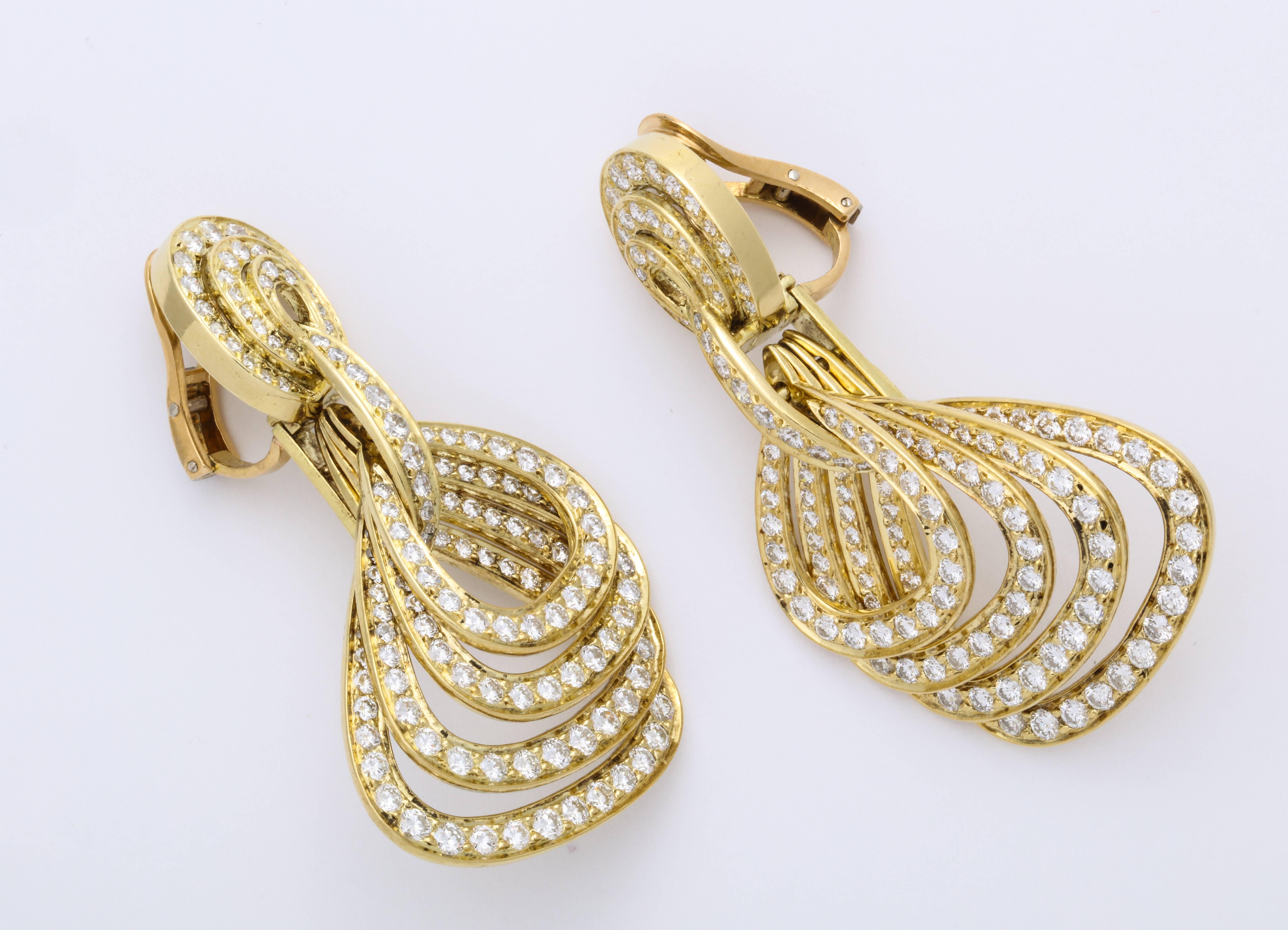 Graduating quadruple lozenge-shape articulating cutouts suspended from oval earrings decorated with colorless round brilliant-cut diamonds weighing 11.86 carats mounted on 18K yellow gold.

