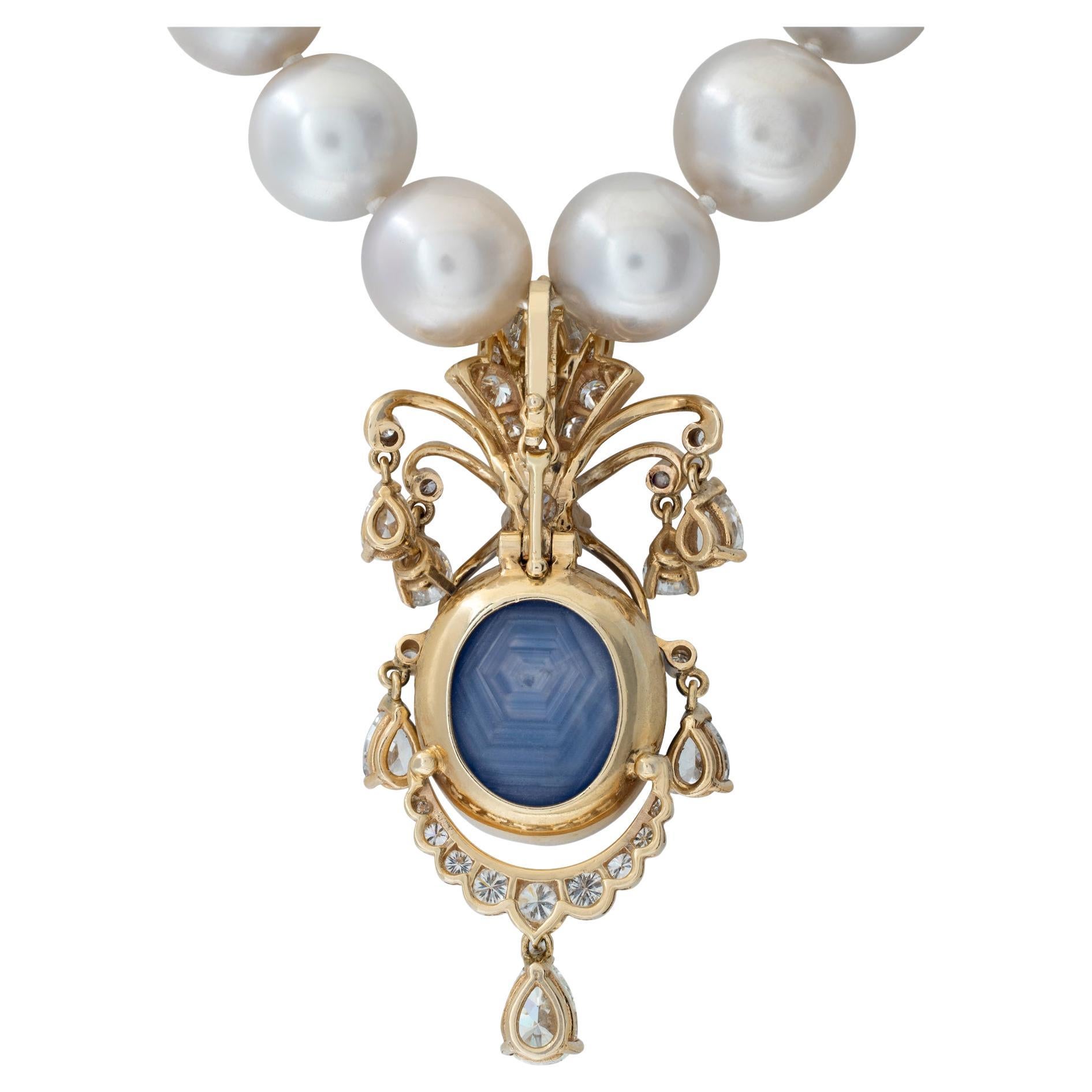 Graduating South Sea Pearl necklace with cabochon star sapphire & diamonds enhancer in 14K yellow gold. Necklace has 35 South Sea Pearl graduating from 10 mm to 12.5 mm with pave diamonds globe clasp. Enhancer has one center cabochon star sapphire