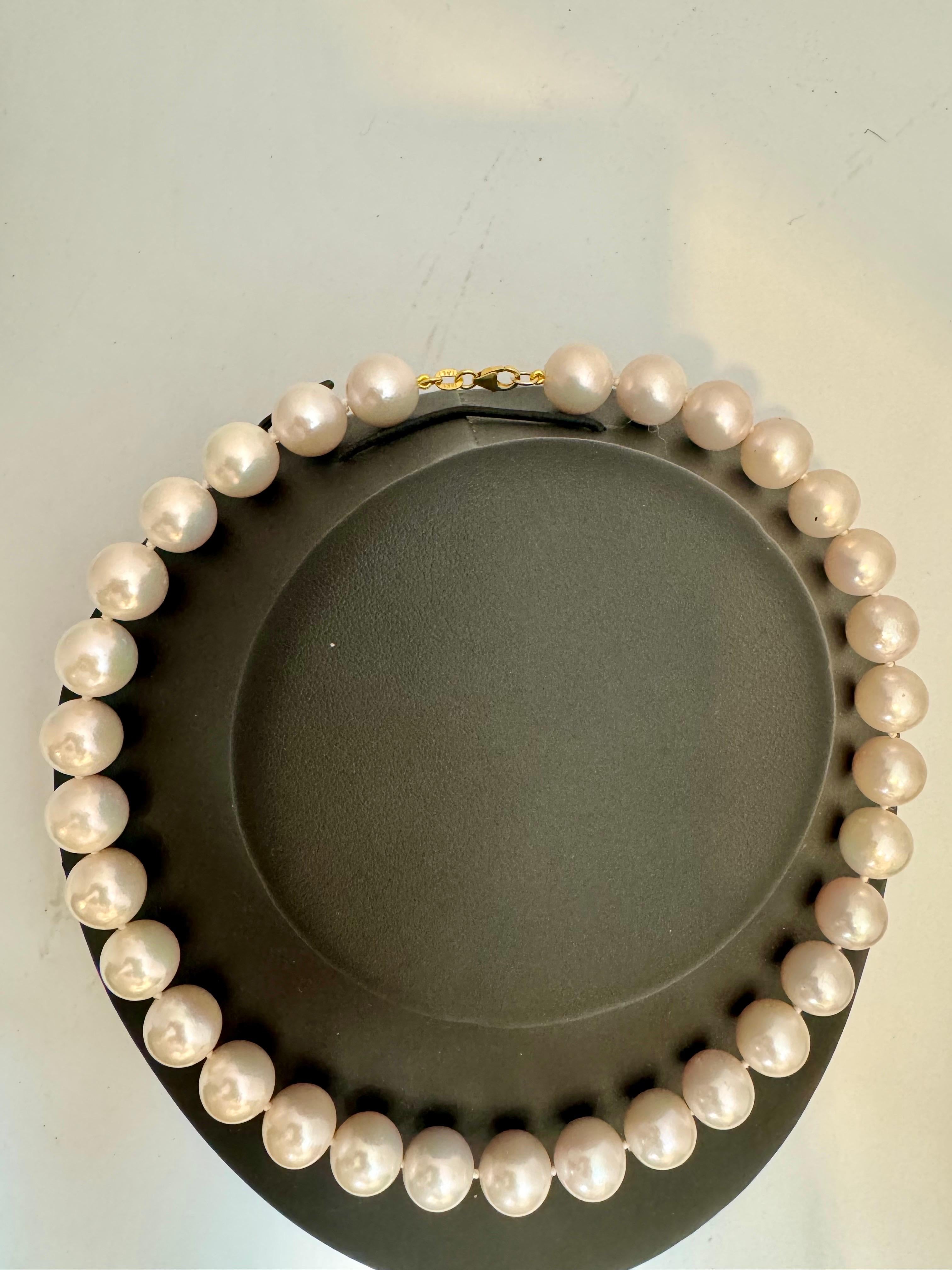 This 16-inch strand necklace features a collection of 32 exquisite white Round South Sea  pearls, ranging from 12 to 14mm in size. The pearls are beautifully complemented by a Yellow Gold clasp, adding a touch of elegance. With a total weight of 97