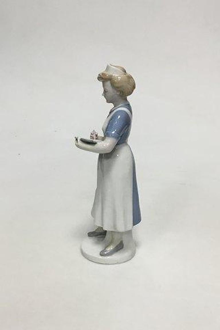 Gräfenthal Thüringen Deutsche Porzellanfigur einer schreibenden Krankenschwester. 

Maße 22,5 cm / 8 55/64 in.