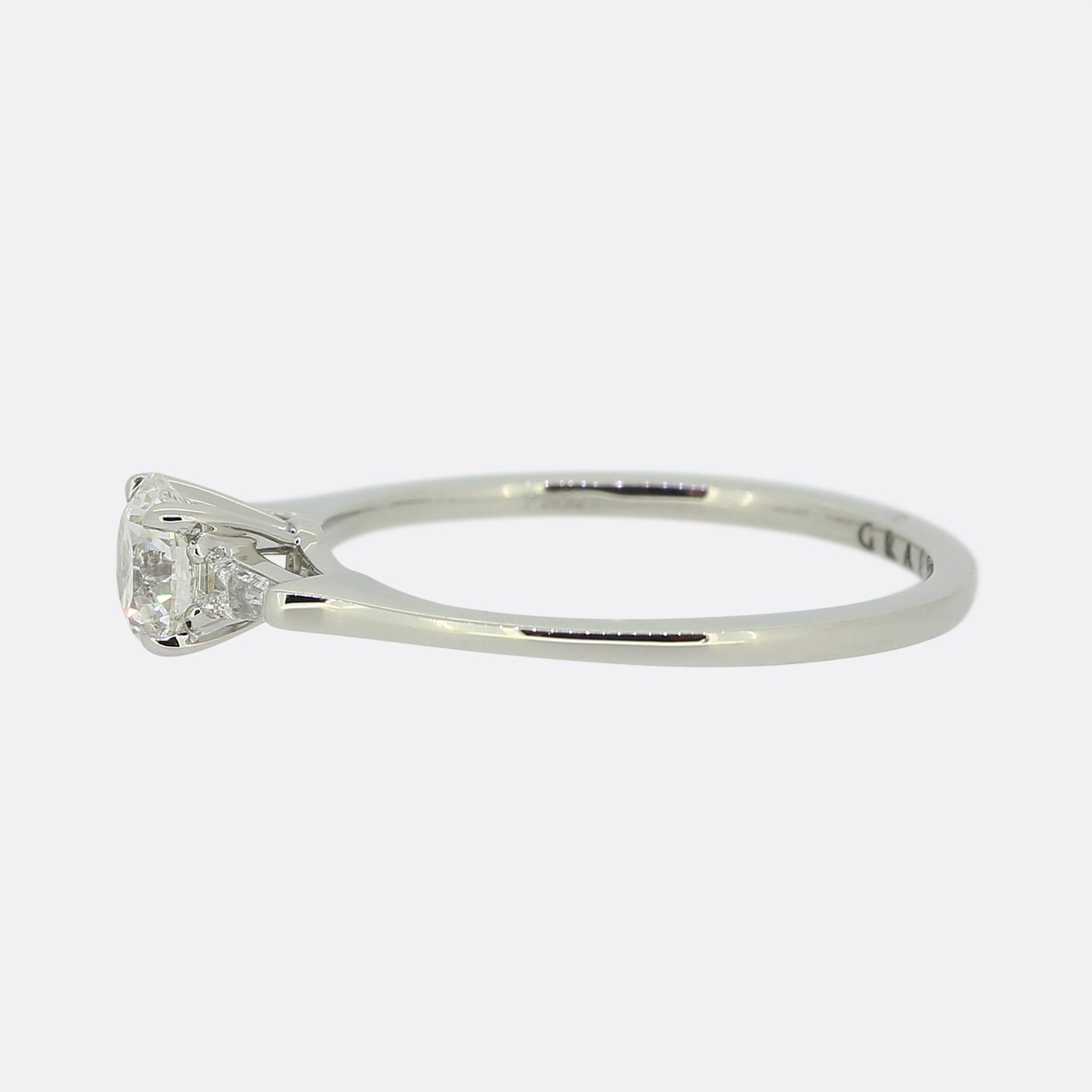 Here we have a fabulous diamond engagement ring from the luxury jewellery designer Graff. The ring features a single round brilliant cut diamond at the centre. This principal stone sits slightly risen and is flanked on either side by a single