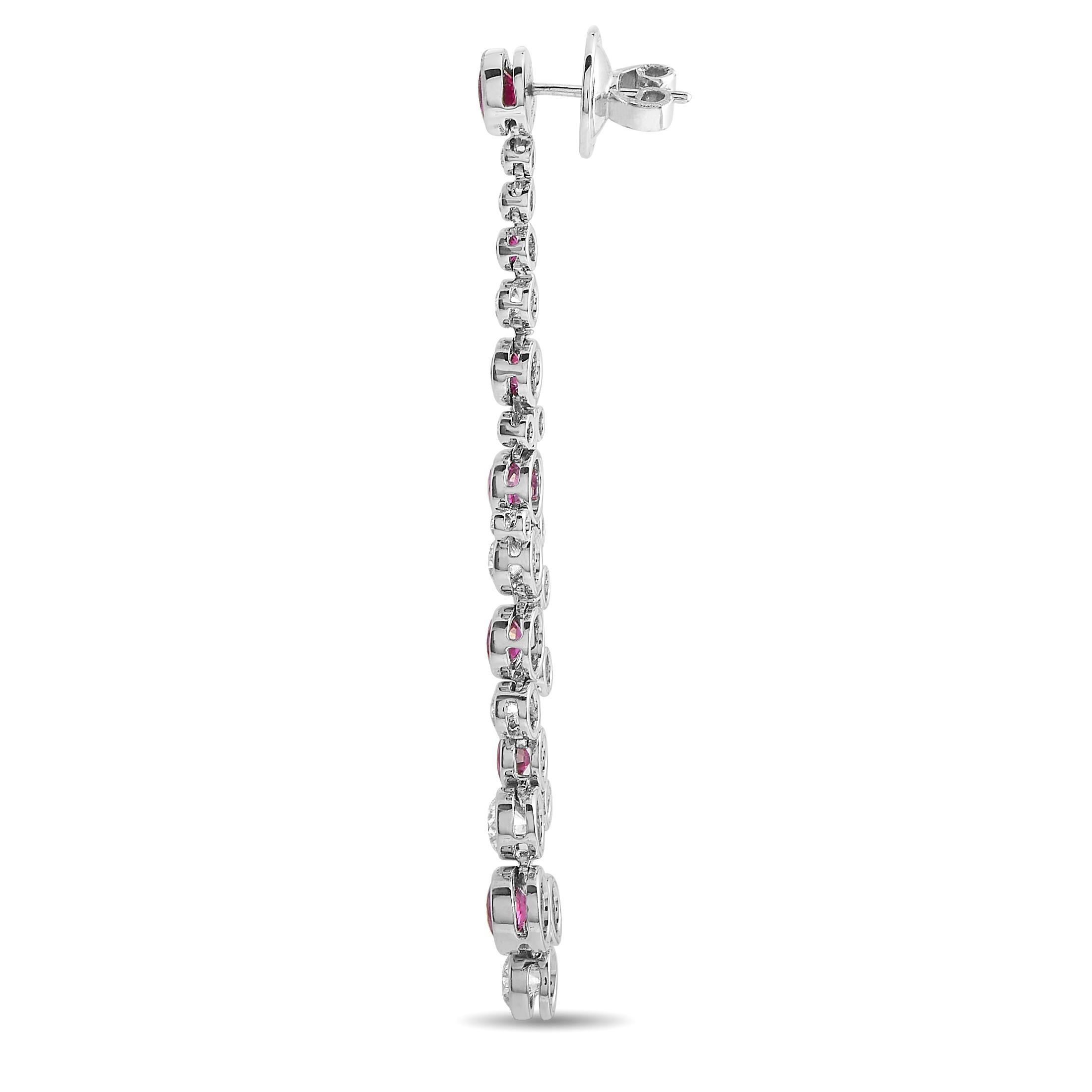 These dramatic drop earrings are simply unforgettable. Glittering diamonds totaling 3.97 carats with E color and VVS1 clarity contrast beautifully against 14 opulent red rubies with a total weight of 5.40 carats. Set within a shimmering, creative
