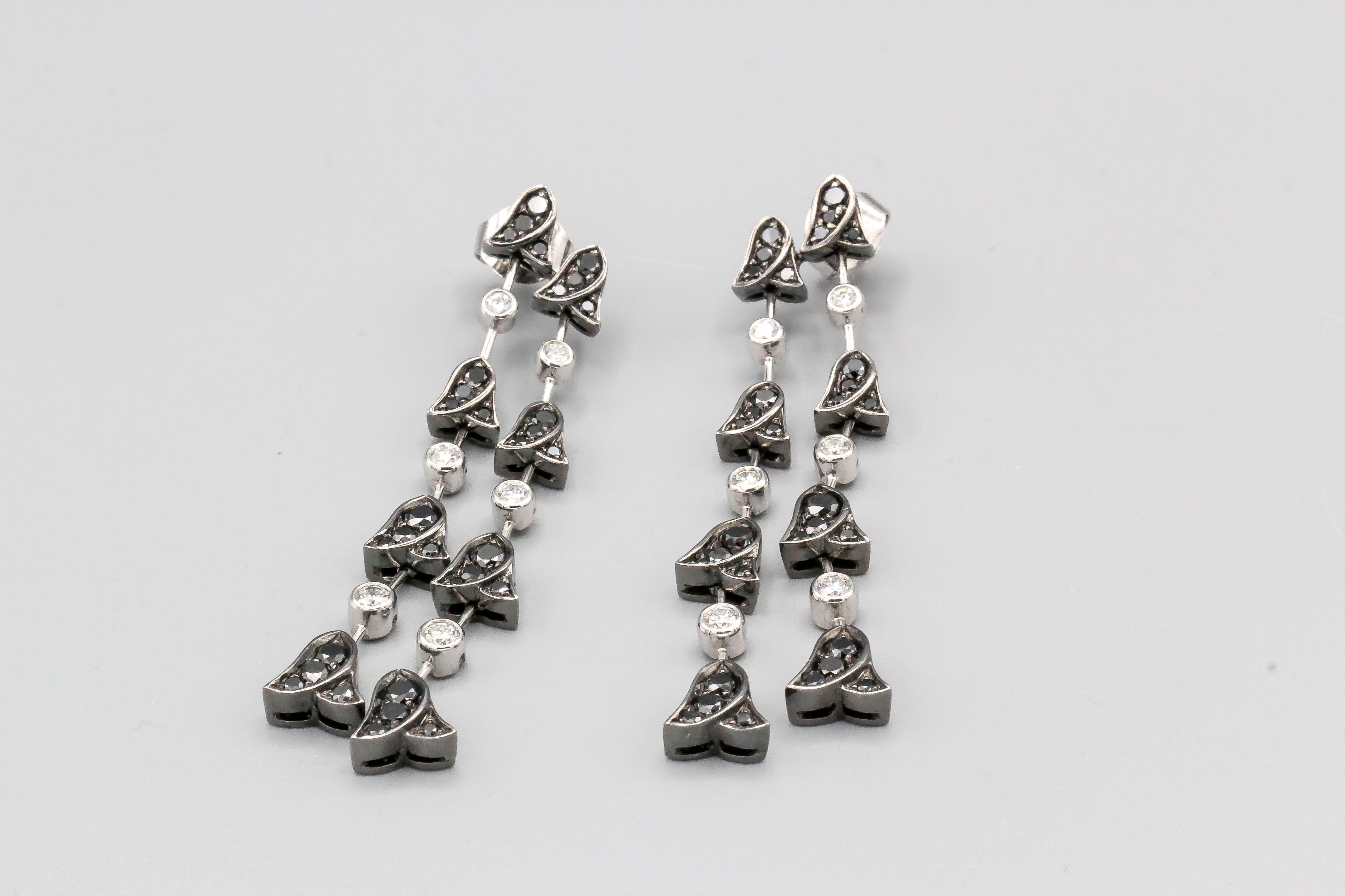 Fine pair of black and white diamond earrings, by Graff.  The earrings are designed as a series of hanging flowers.  Diamonds are all high grade round brilliant cut, and are set in white and blackened 18k gold. 

Hallmarks: Graff, 750, reference