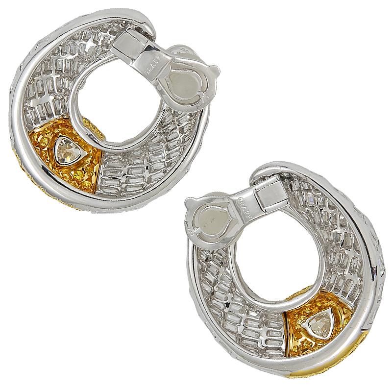 A pair of Graff diamond and yellow hoop earrings in 18k white gold; each designed as a series of baguette diamond columns to a pave-set yellow diamond central section, and set at the centre with a fine heart-shaped diamond.
 
1) H/S -1.0ct, E VS1
2)