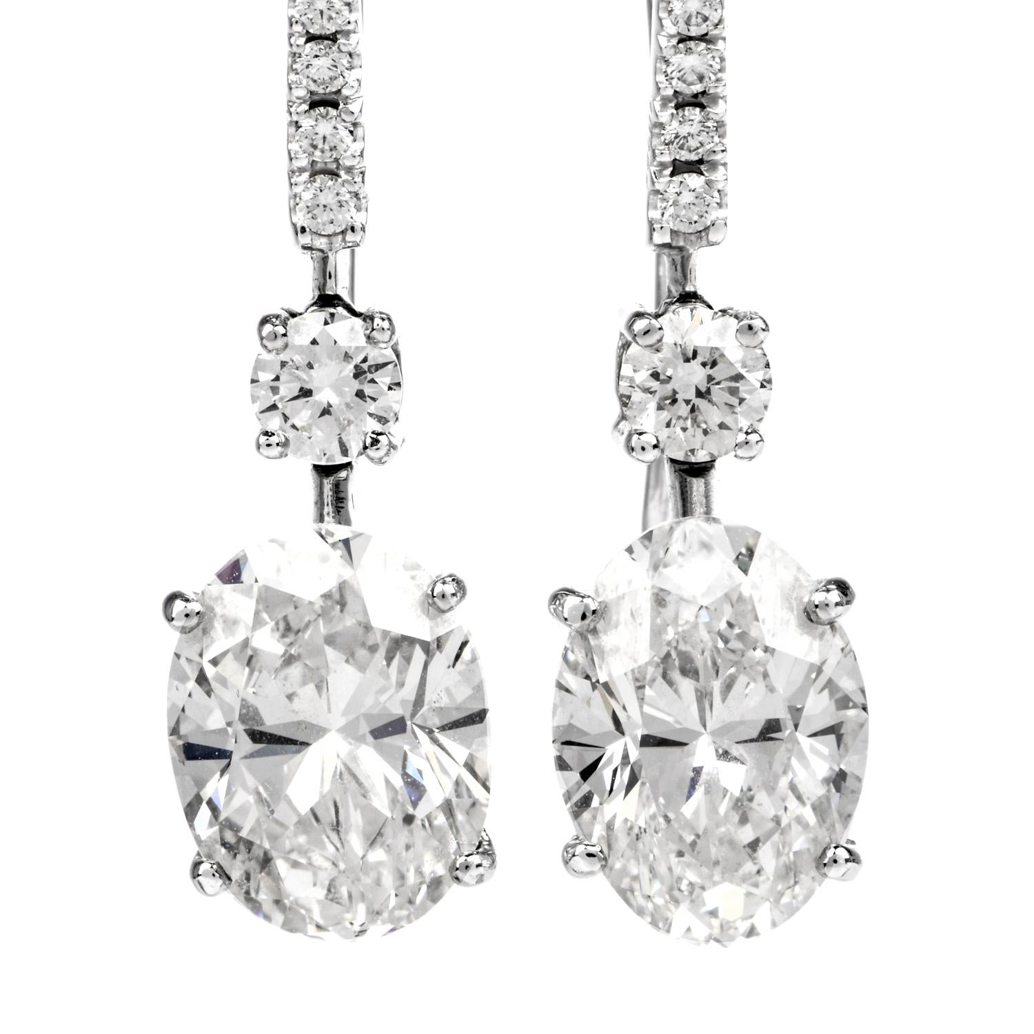 This stunning pair of diamond dangle huggie earrings is crafted in solid platinum by famed jeweler Graff, weighing 4.8 grams and measuring 30mm long x  7mm wide. Composed of two prominent prong-set oval brilliant GIA lab reported diamonds, one