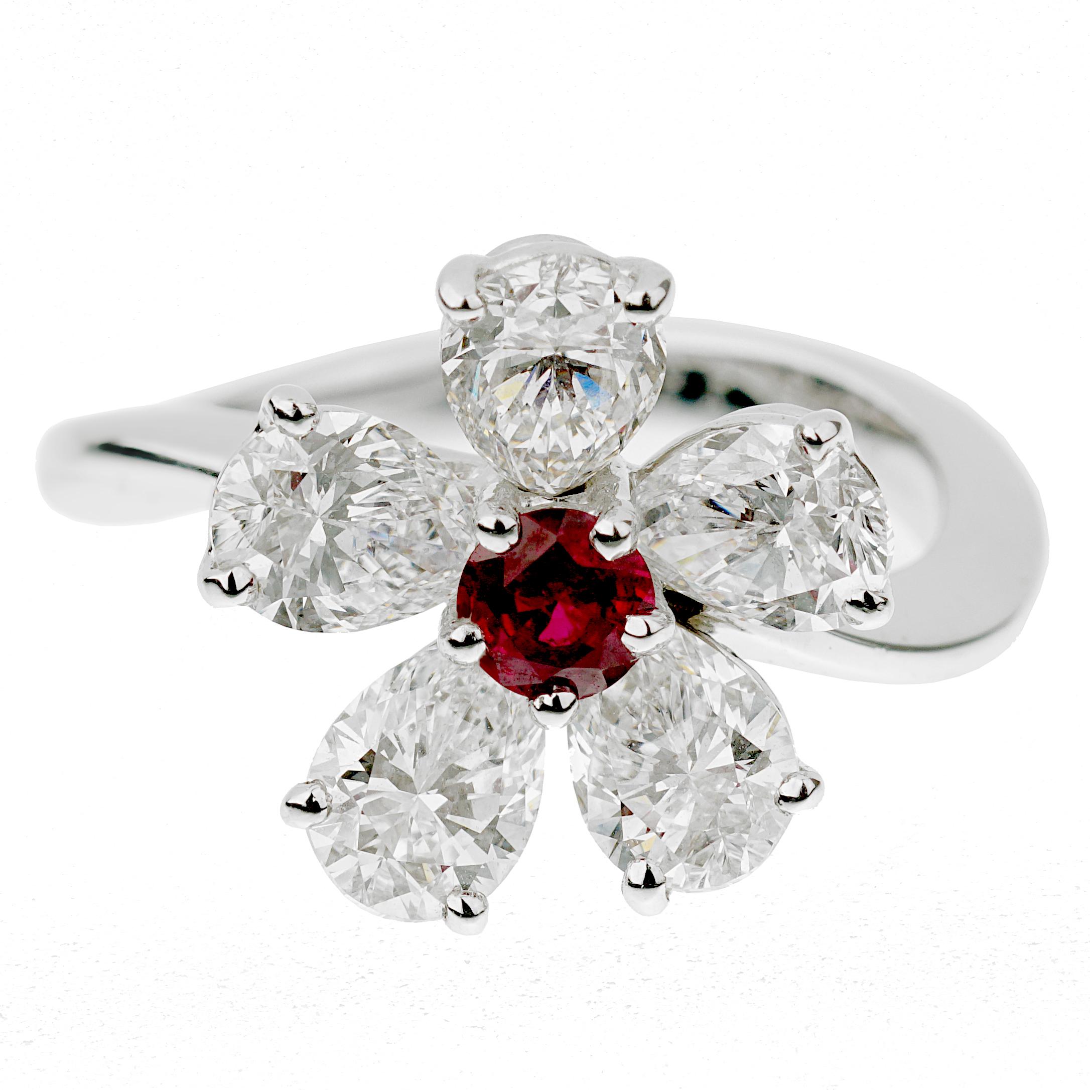An authentic Graff cocktail ring showcasing 5 pear shaped diamonds (2.65ct appx) surrounding a ruby measuring .25ct appx designed in a floral motif. The ring is crafted in platinum and in excellent condition. The ring measures a size 6 and can be