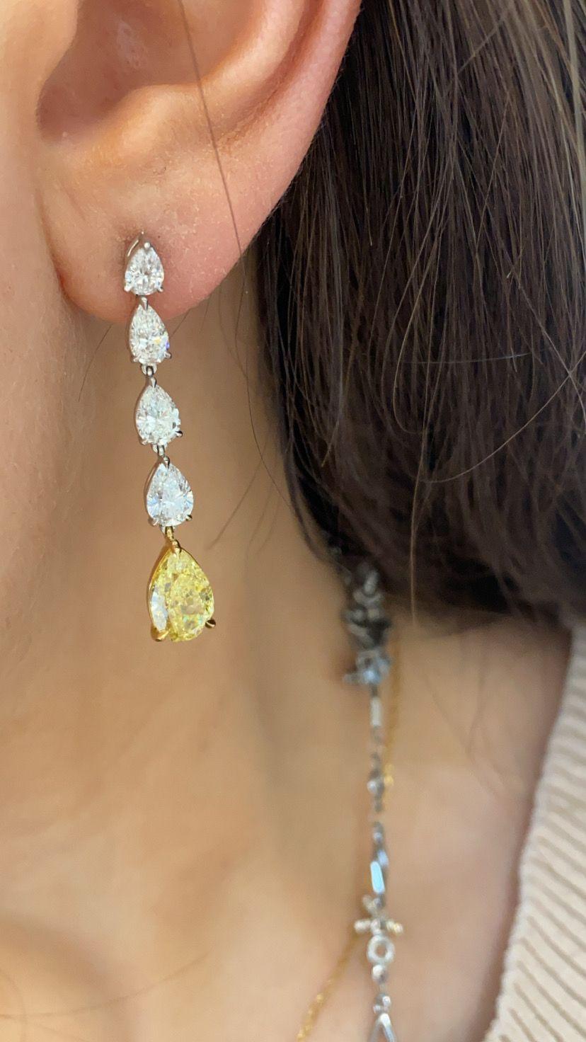 Classic Graff signed diamond drops feature an elegant display of hanging pear shaped graduating diamonds set in platinum and white gold with a 1.87 and 1.81 fancy vivid yellow diamond drop at the bottom. From the Graff timeless collection, the fancy