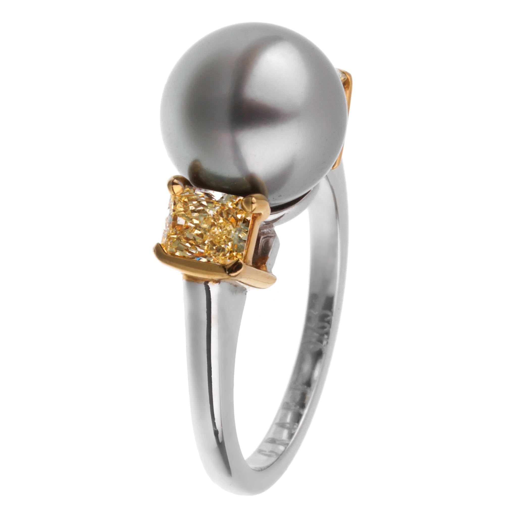 An impressive Graff diamond cocktail ring showcasing a 9.8mm gray pearl adorned by 2 radiant cut yellow diamonds set in 18k yellow gold. The ring is crafted in platinum and measures a size 5 1/2 and can be resized.