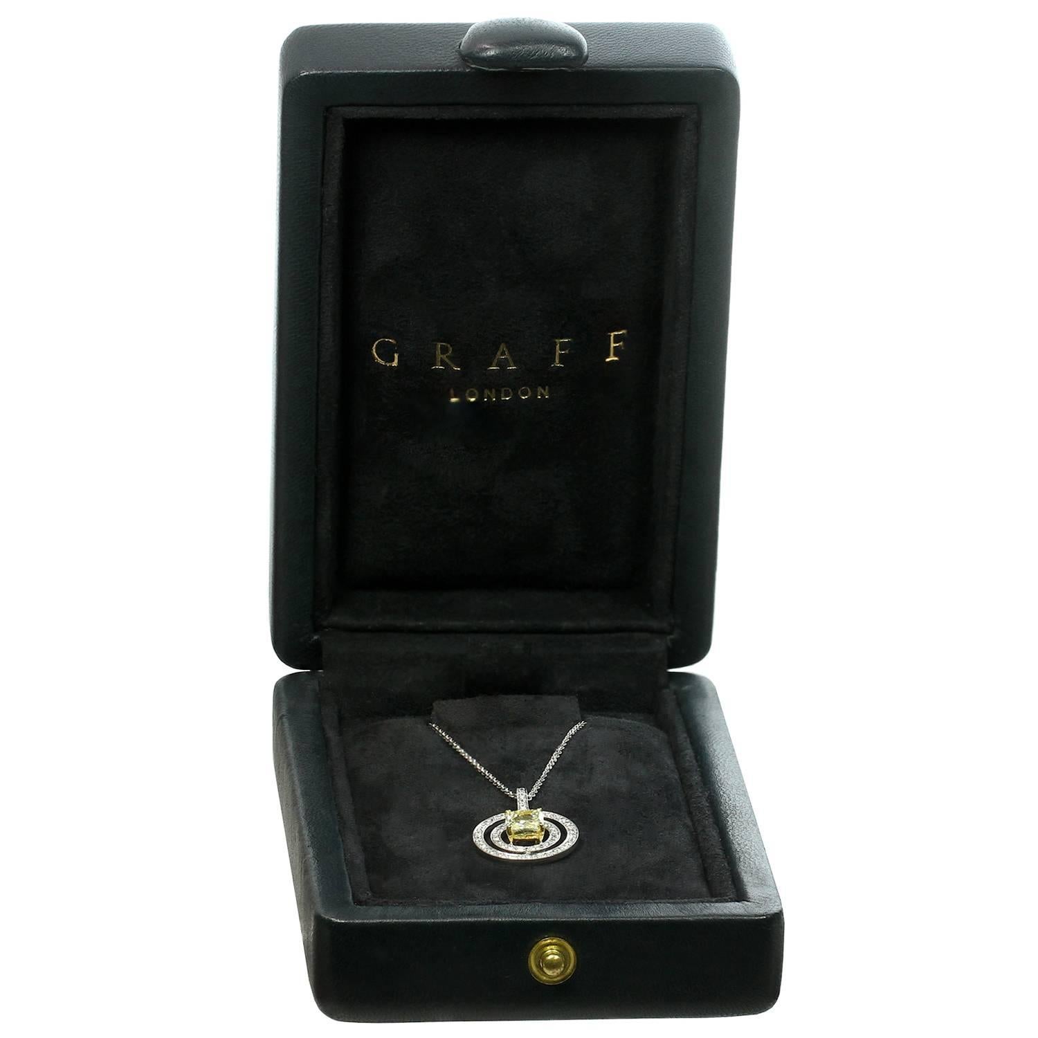 This exquisite Graff round pendant on a fine link chain is crafted in fine platinum and features a Fancy Yellow VVS1 Clarity Cut-Cornered Square Modified Brilliant Diamond center stone weighing an estimated 1.05 carats and prong-set in 18k yellow