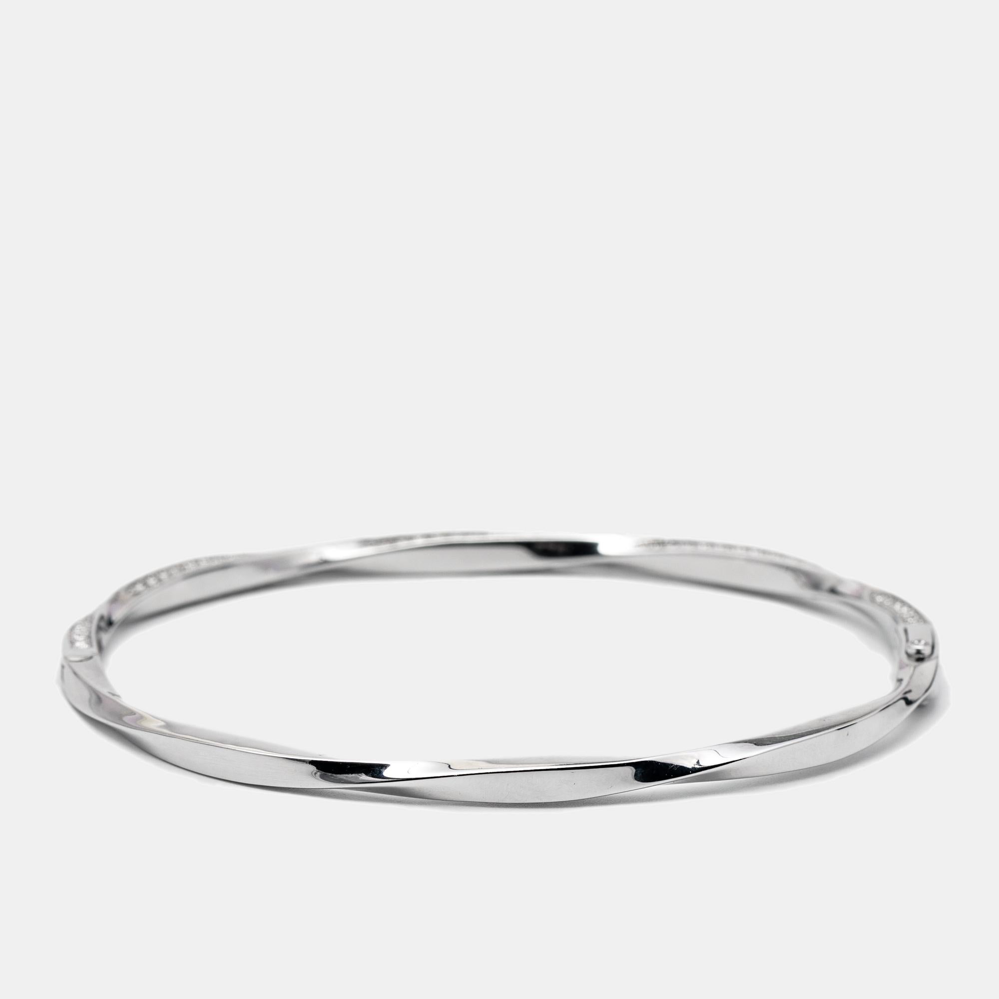 Modern, chic, and minimal, this Graff bangle bracelet is made for the woman of today! It has been sculpted using 18k white gold and studded with carefully-placed diamonds on its smooth surface. Stack it with a watch, other bangles, or wear it as