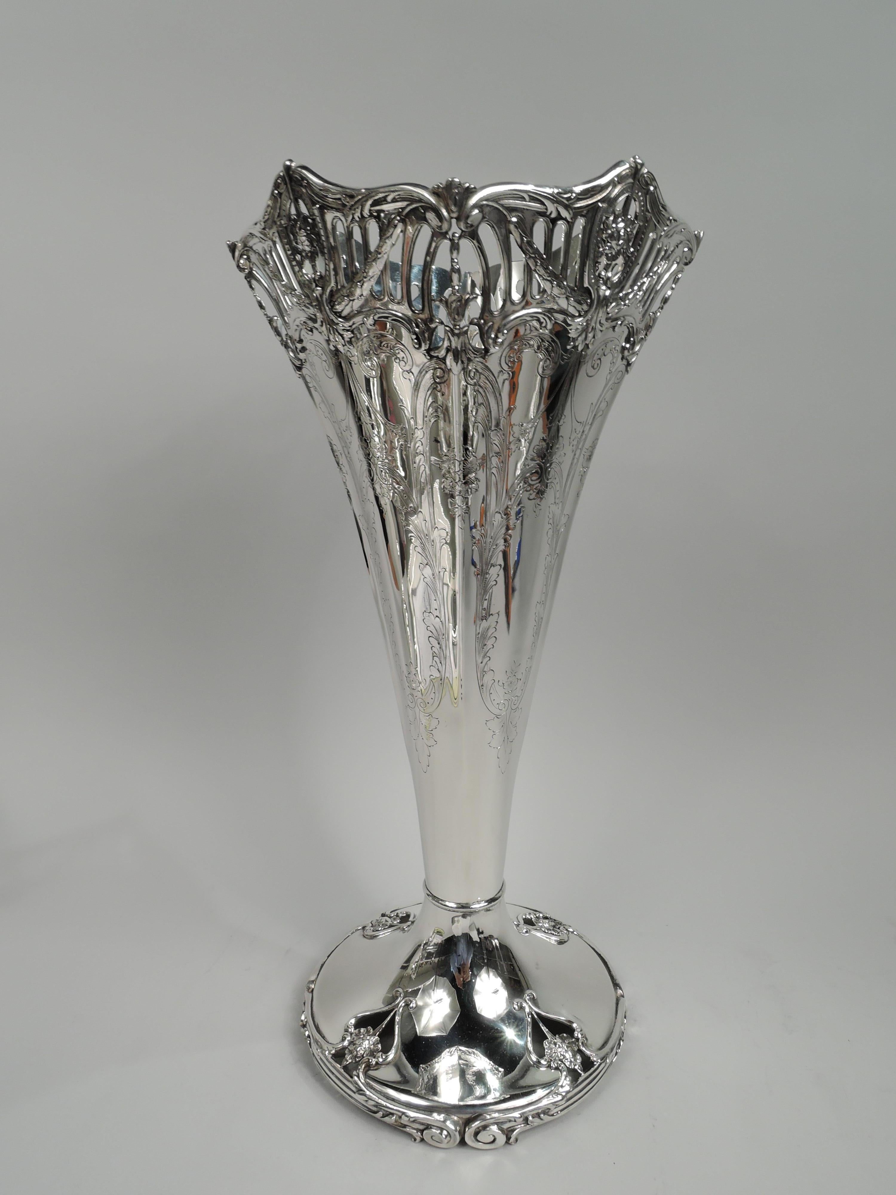 Edwardian Regency sterling silver trumpet vase. Made by Graff, Washbourne & Dunn in New York, ca 1910. Four curved sides. At top tubular piercing overlaid with swags, and open heraldic shields inset with pendant flowers. Rims scrolled and