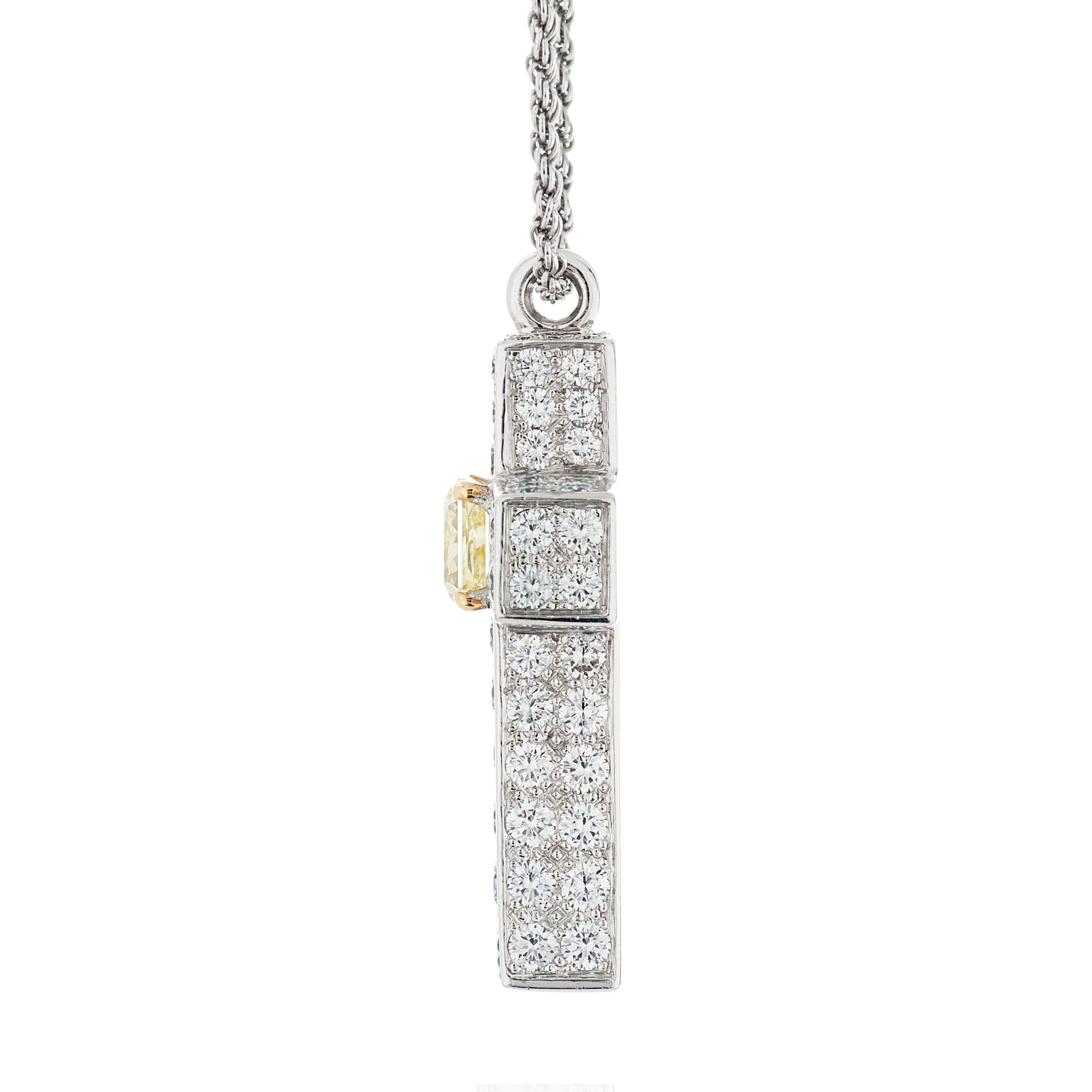 Graff white and fancy yellow diamond cross pendant necklace in 18 karat white gold.

This Graff cross features a 1.50 carat fancy yellow radiant cut diamond with VS1 clarity, accompanied by a GIA report.  An additional 112 round brilliant cut