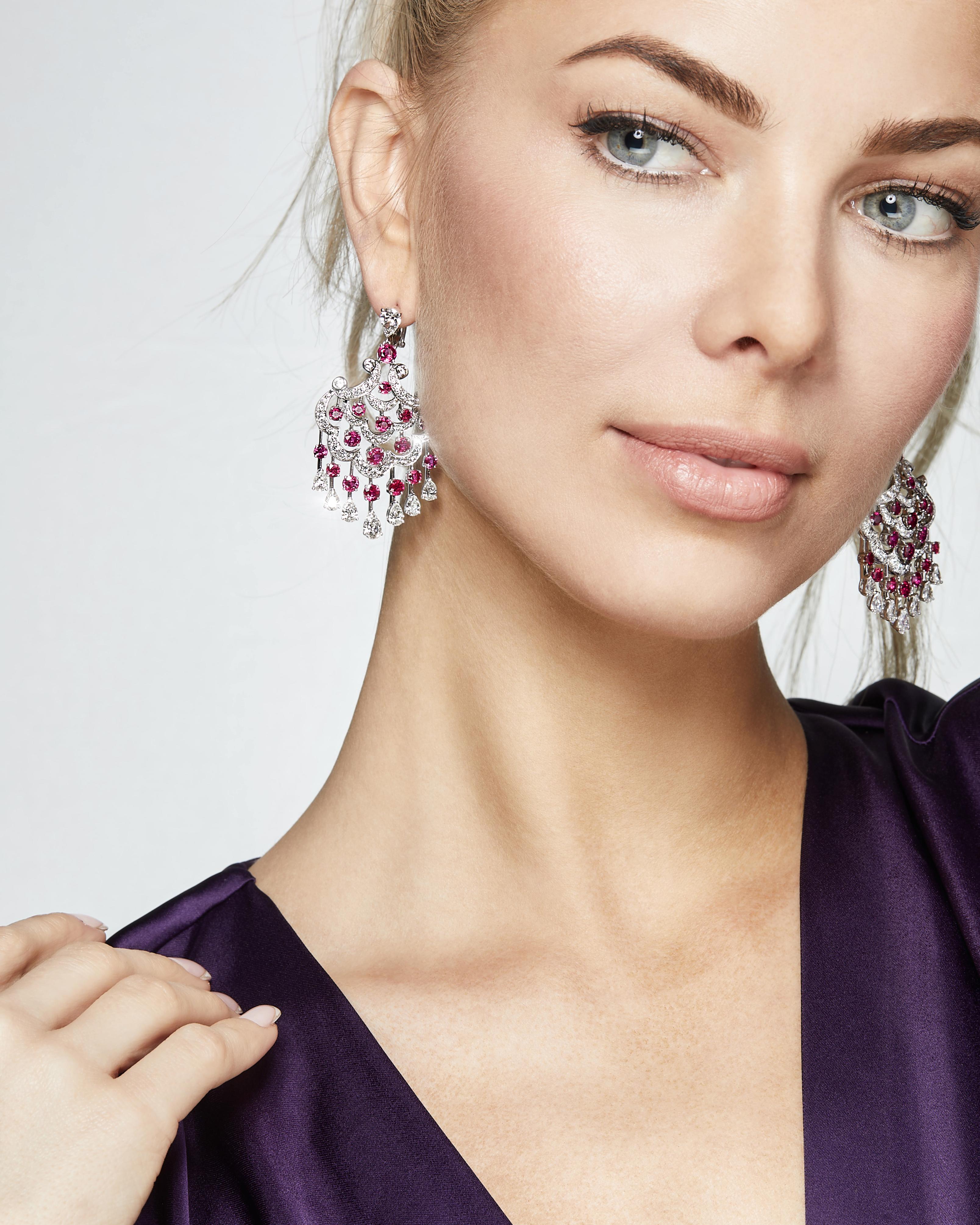 Introducing an elegant chandelier design, this Graff earrings feature a stunning array of round rubies and 16 pear-shaped white diamonds in 18-karat white gold. The elaborate design with diamonds cascading down in multiple tiers resembles a