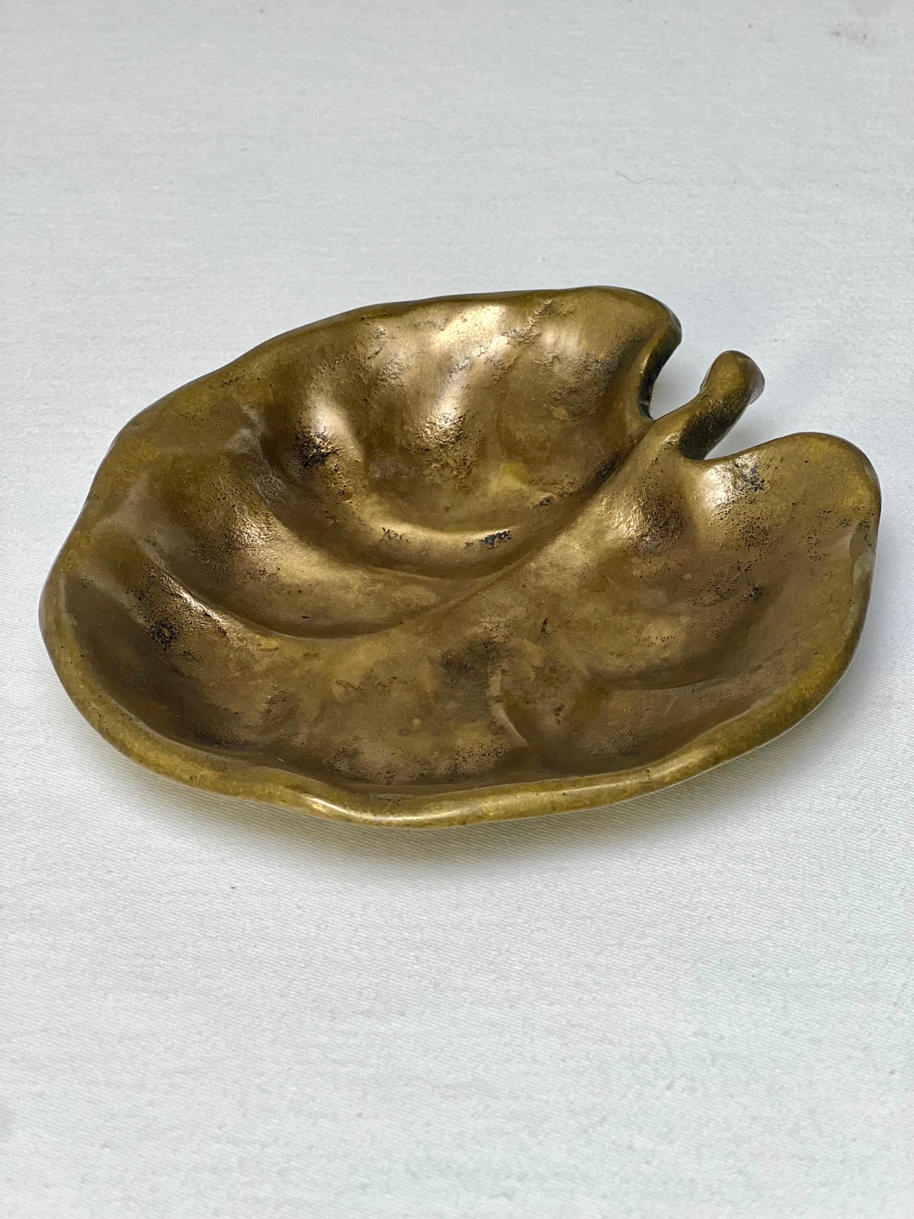 Solid bronze leaf form trinket or valet dish, signed Graham Bronze.

A lovely work with smooth organic shaped edge and gently curved details. Beautiful alone or handy for rings, keys, or any important small items. Perfect for a vanity, desk, entry